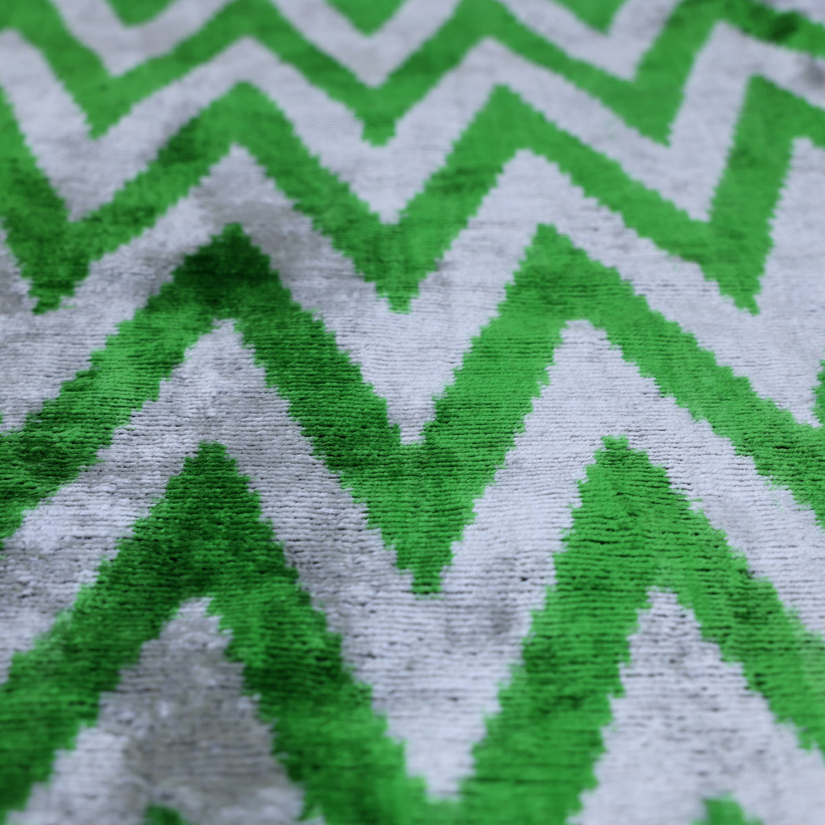 Close view of bright green and light gray chevron zigzag in soft silk velvet