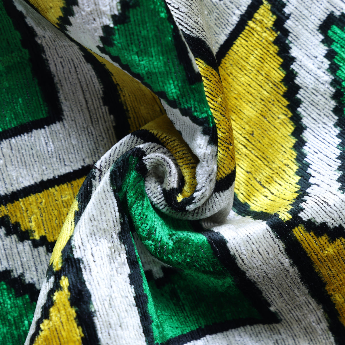 Draped geometric velvet fabric with saffron yellow and emerald teal catching the light