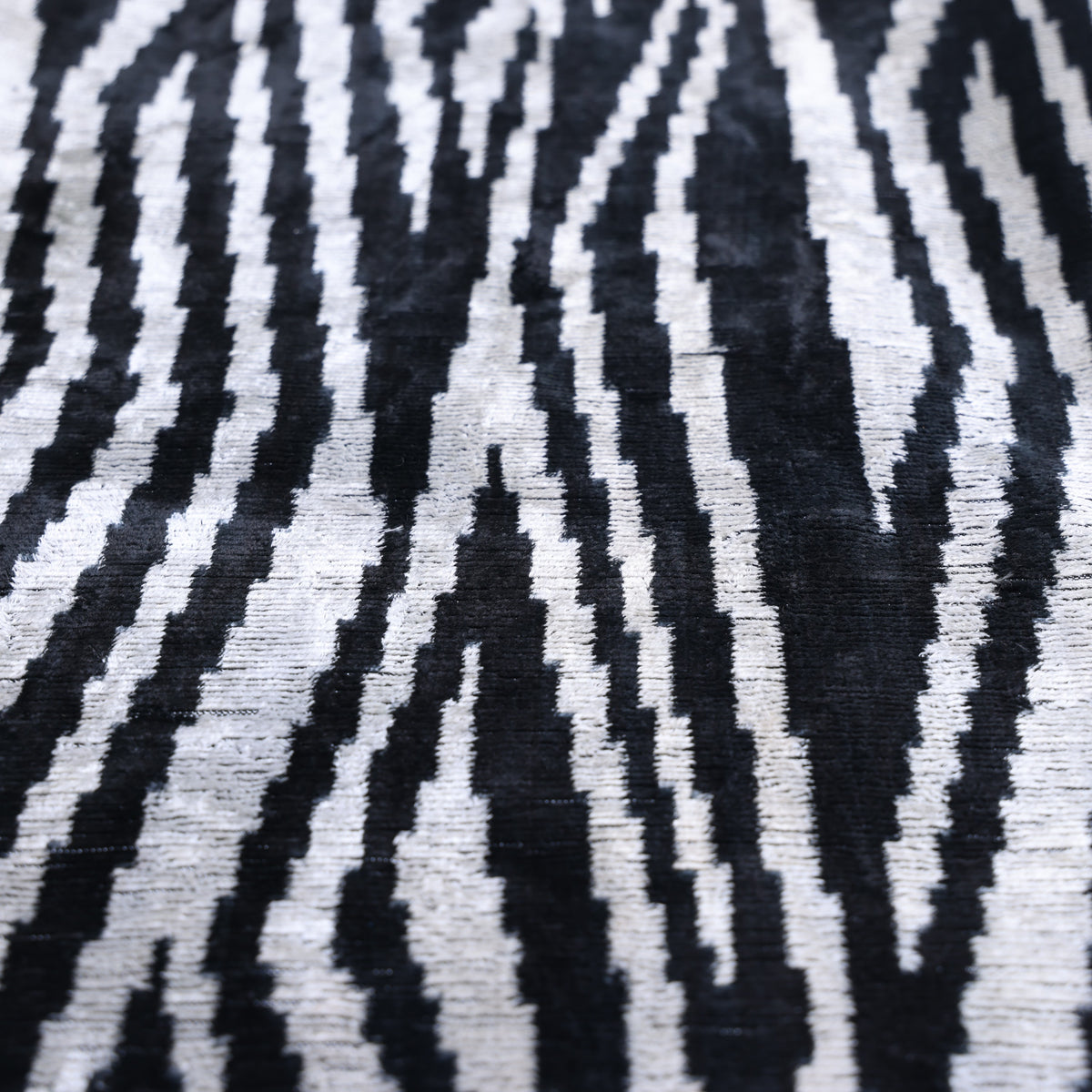 Close-up of inky black and soft ivory zebra stripes across silk velvet