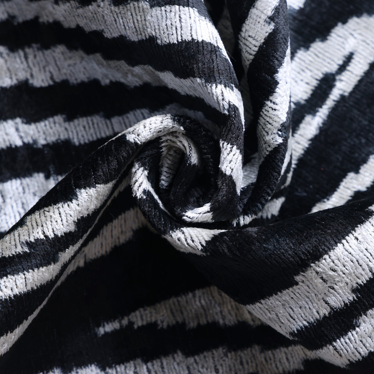 Swirled detail showing the soft sheen and tactile surface of black and ivory velvet