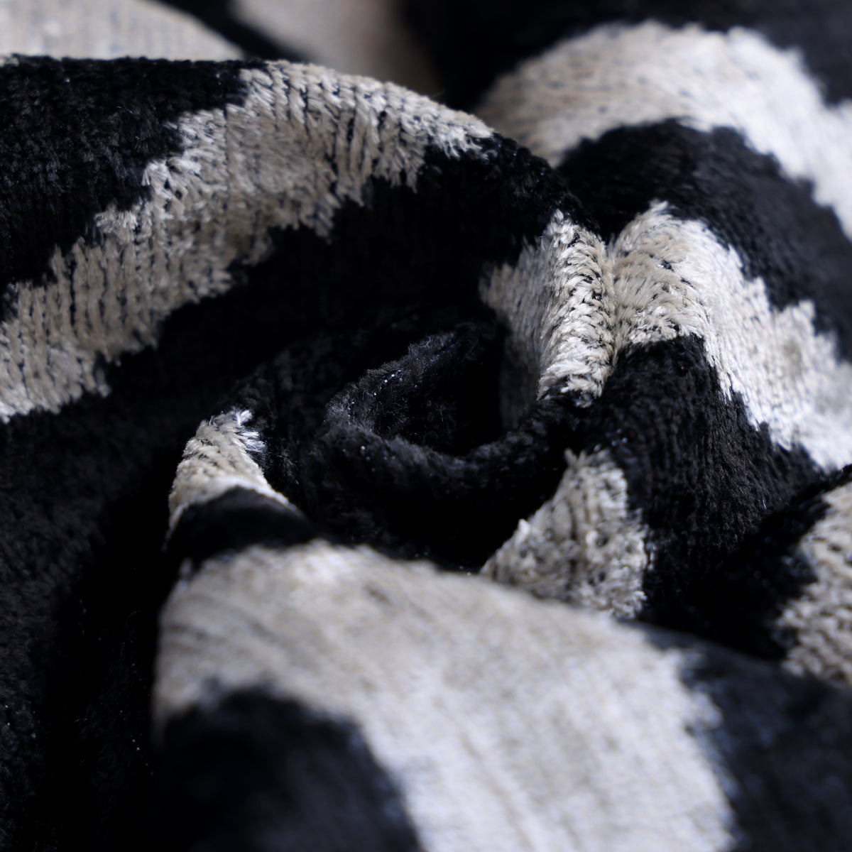 Macro view of gathered silk velvet folds showing plush texture and shifting sheen