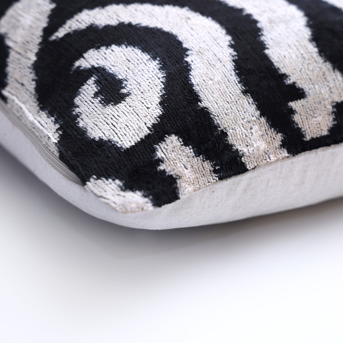 Corner detail of black and ivory velvet face with a neutral linen backing seam