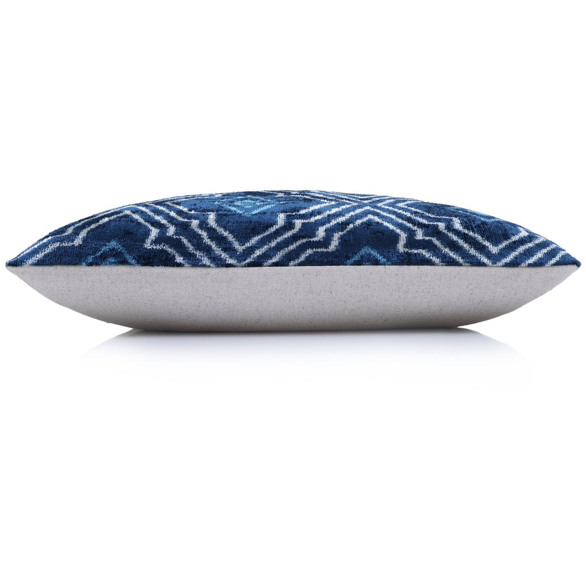 Side profile of blue and white lumbar pillow showing thickness and light backing