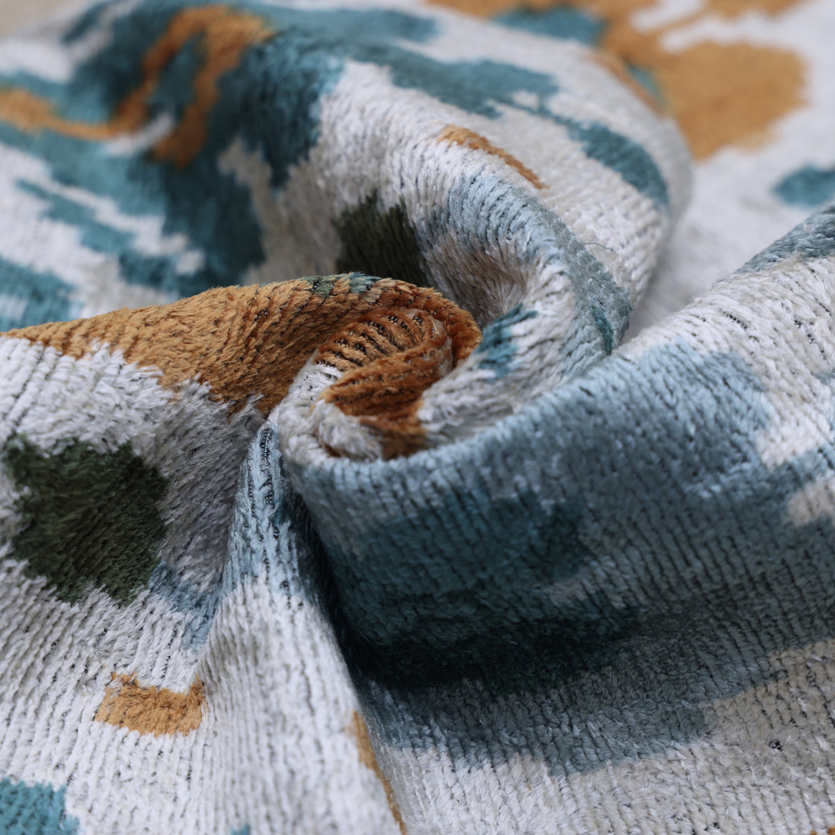 Curled silk velvet edge showing shifting sheen and soft plush pile
