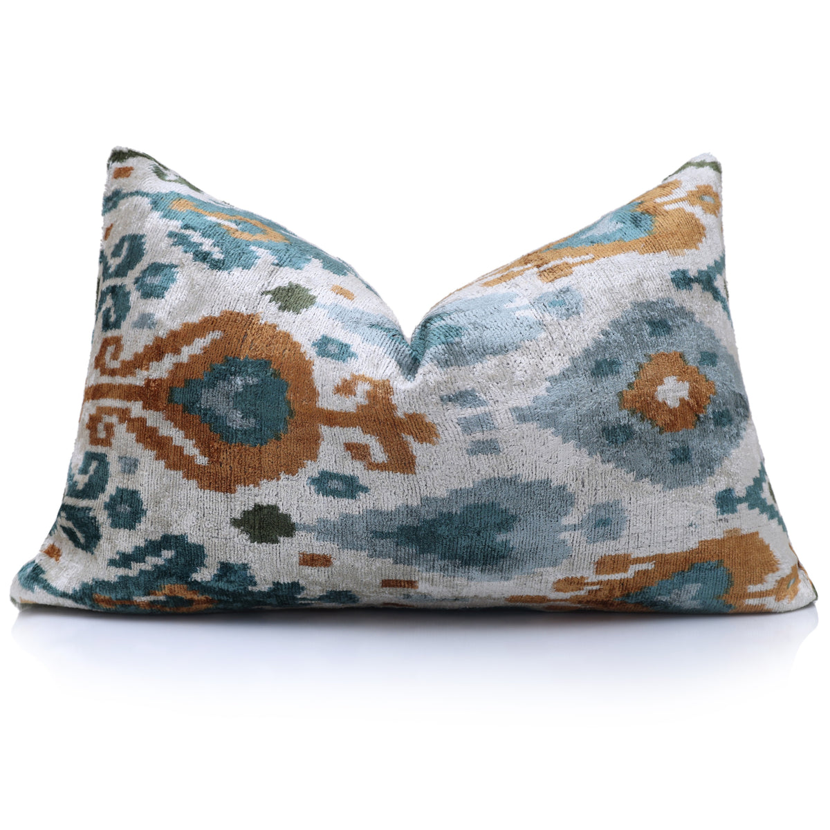 Styled silvery white lumbar pillow with teal and ochre ikat medallion