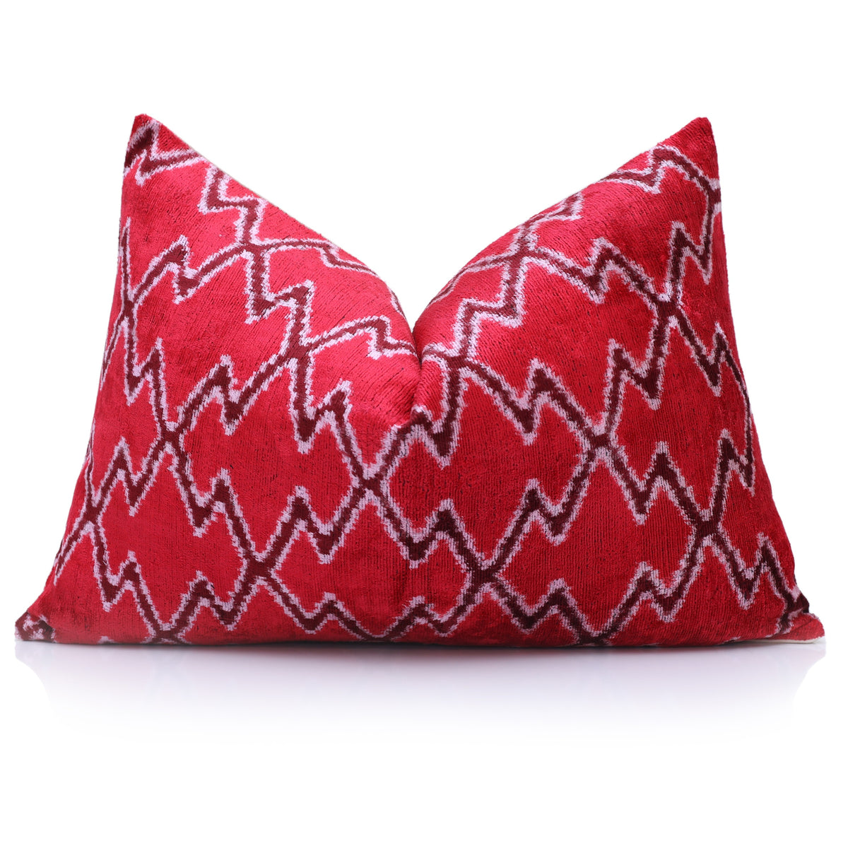 Upright lumbar pillow styled with a center crease and cherry red ikat pattern