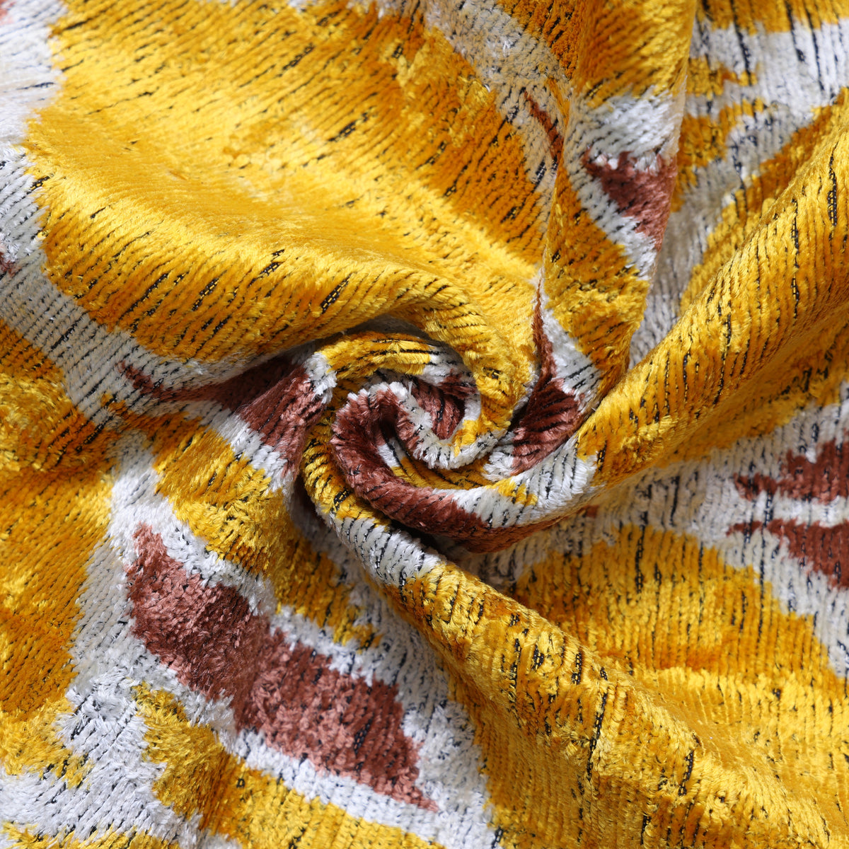 Close view of mustard gold and dusty rose swirled silk velvet fabric