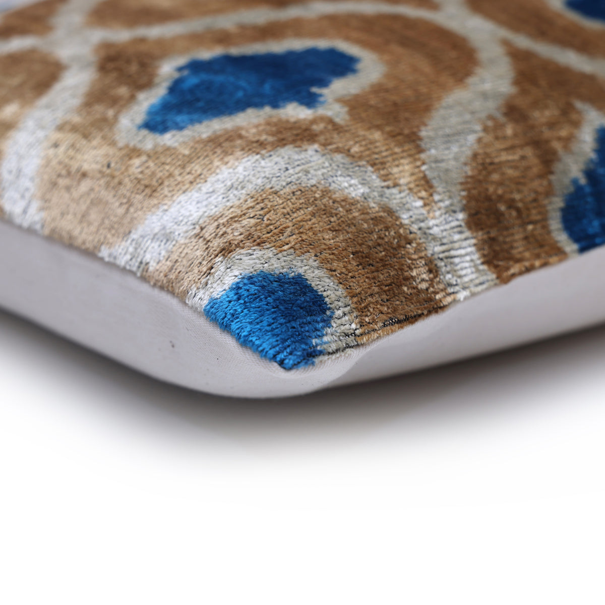 Lumbar pillow corner showing geometric ikat seam and linen backing