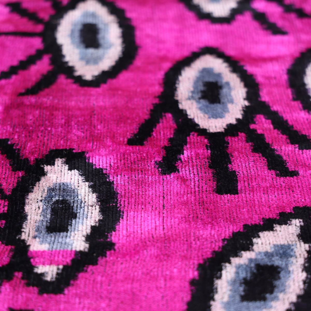 Evil eye ikat pattern in magenta pink, black, white, and slate blue-gray velvet