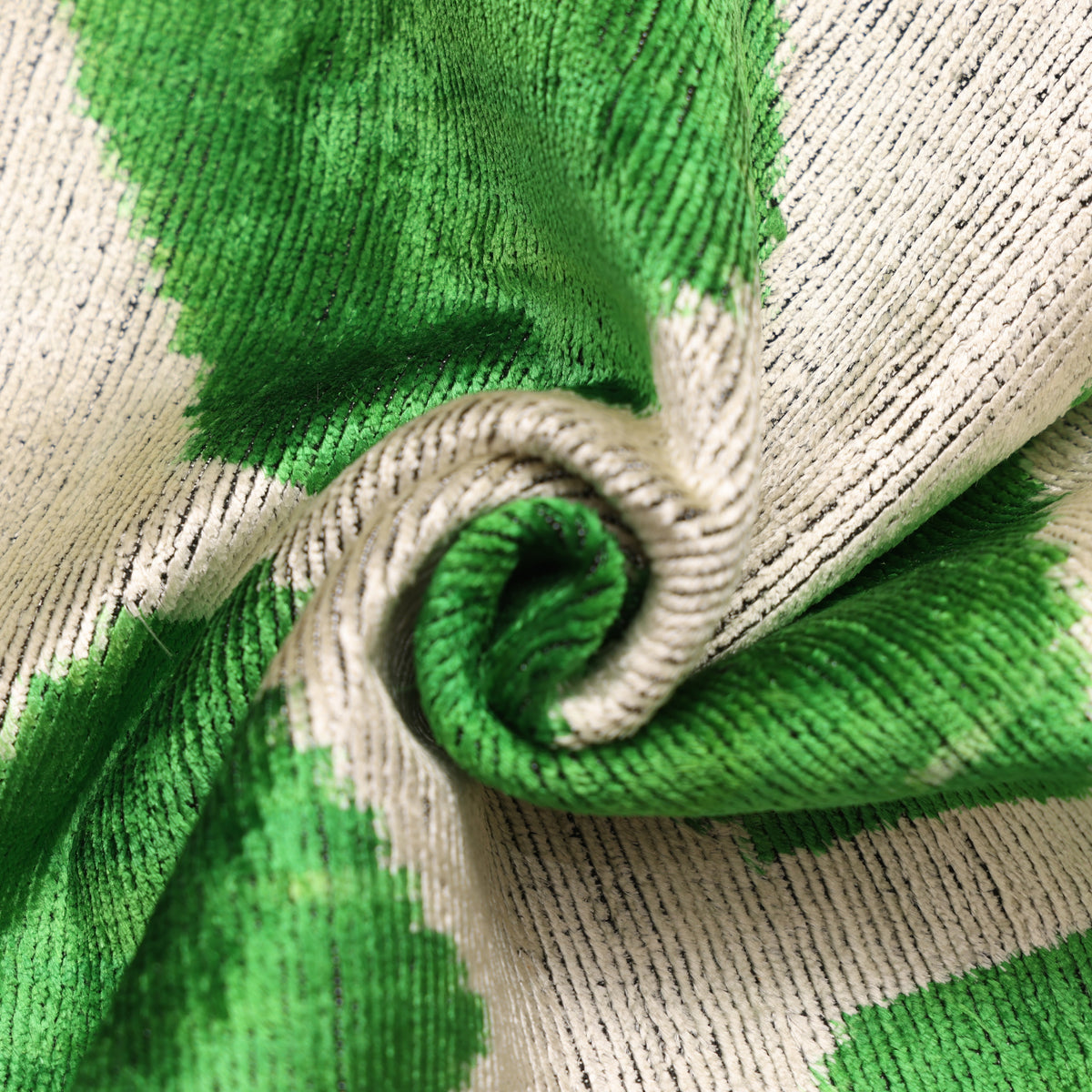 Close-up of emerald green and pale greige velvet showing cut pile ribs and soft sheen