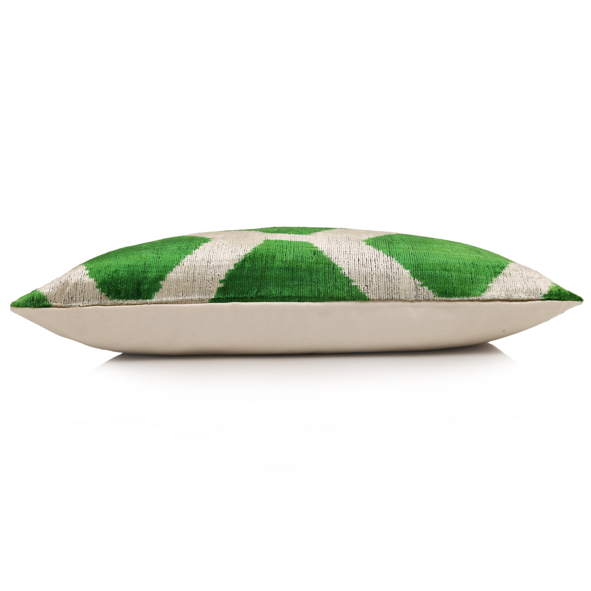 Side profile of emerald green and pale greige lumbar pillow with neutral linen back
