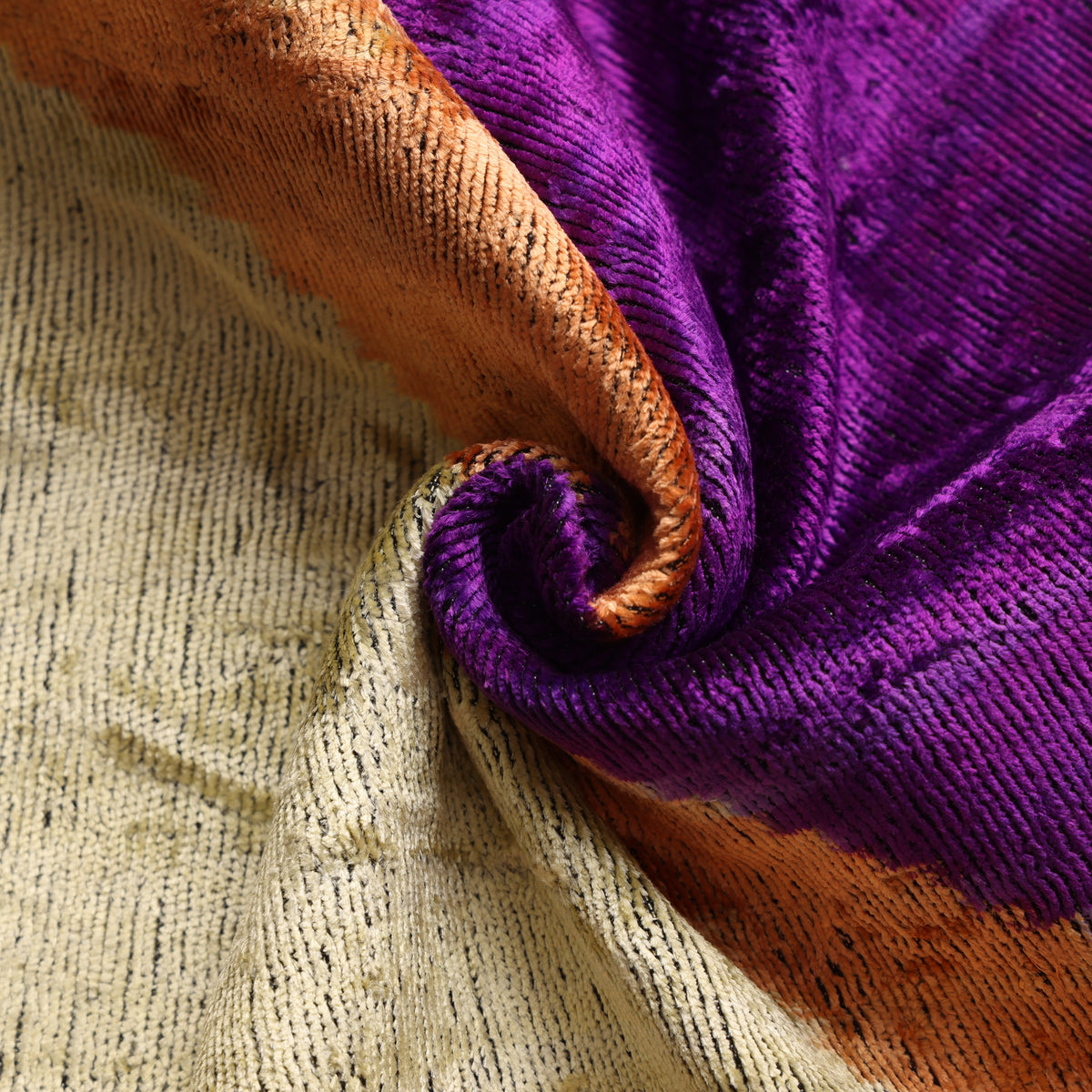 Close view of rich purple silk velvet showing swirled pile and plush sheen