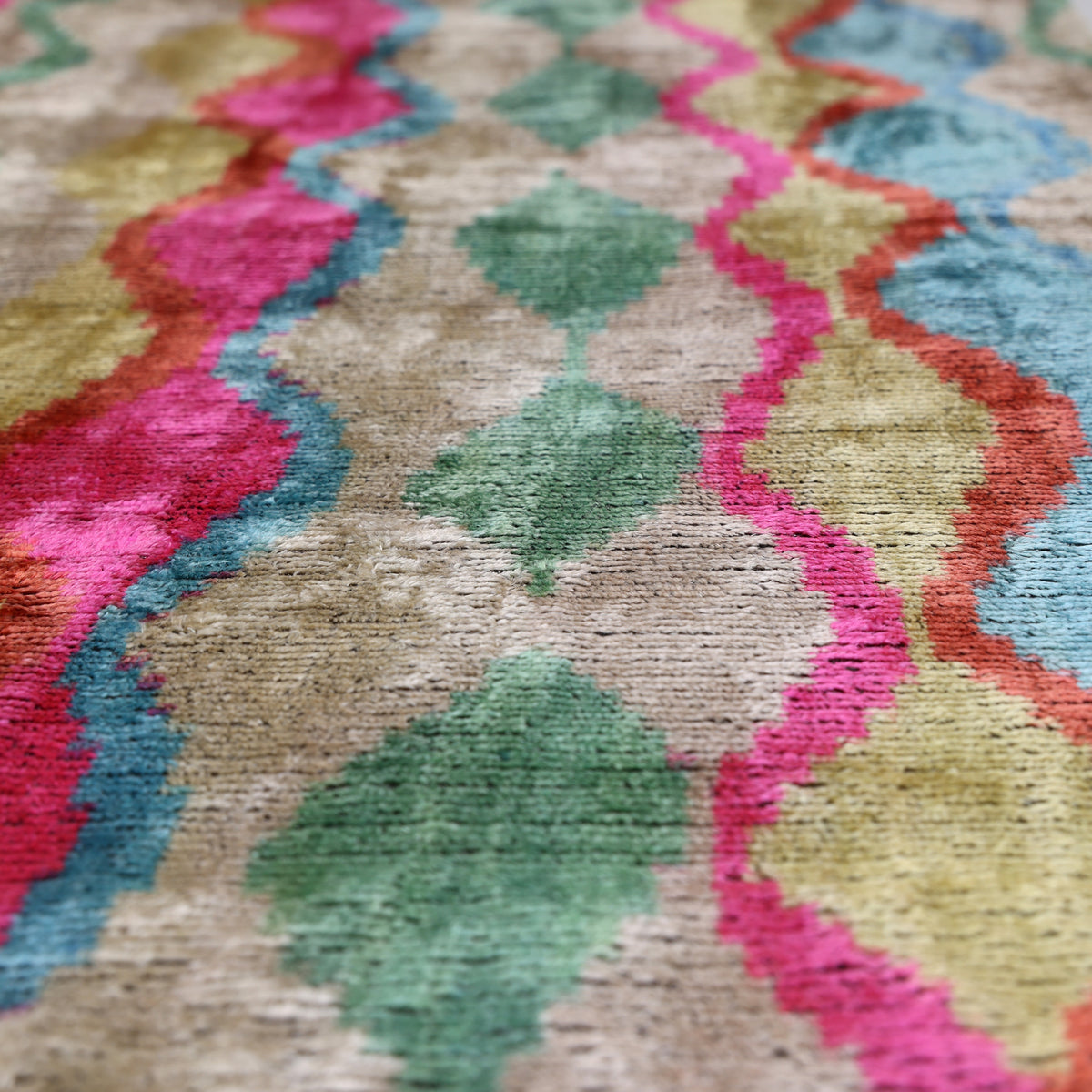 Raking close-up reveals ribbed voided velvet and multicolor wavy ikat pattern