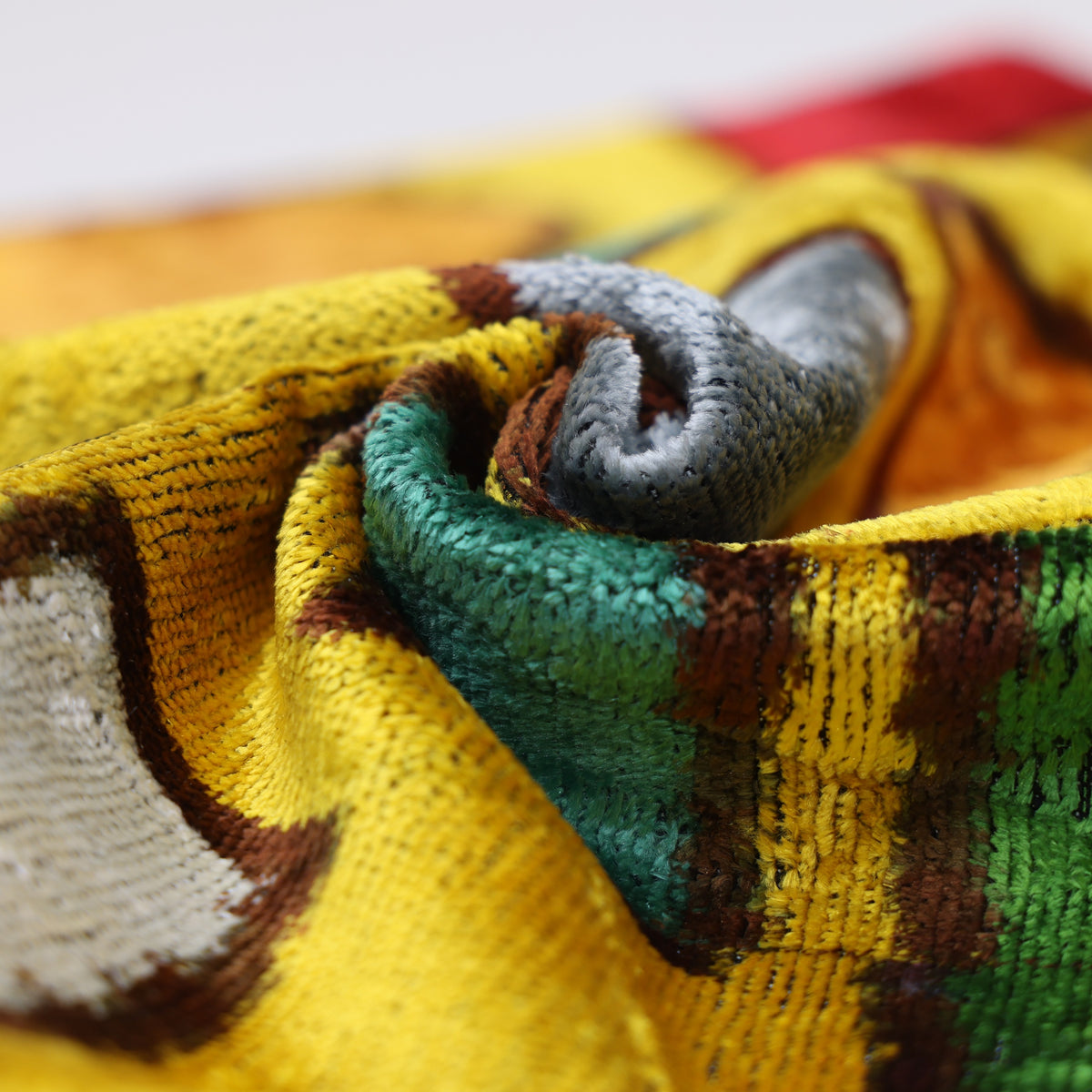 Close view of bright mustard yellow velvet with colorful swirled geometric shapes