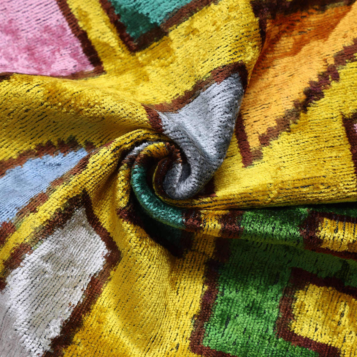 Close-up of multicolor abstract geometric shapes across bright mustard yellow velvet