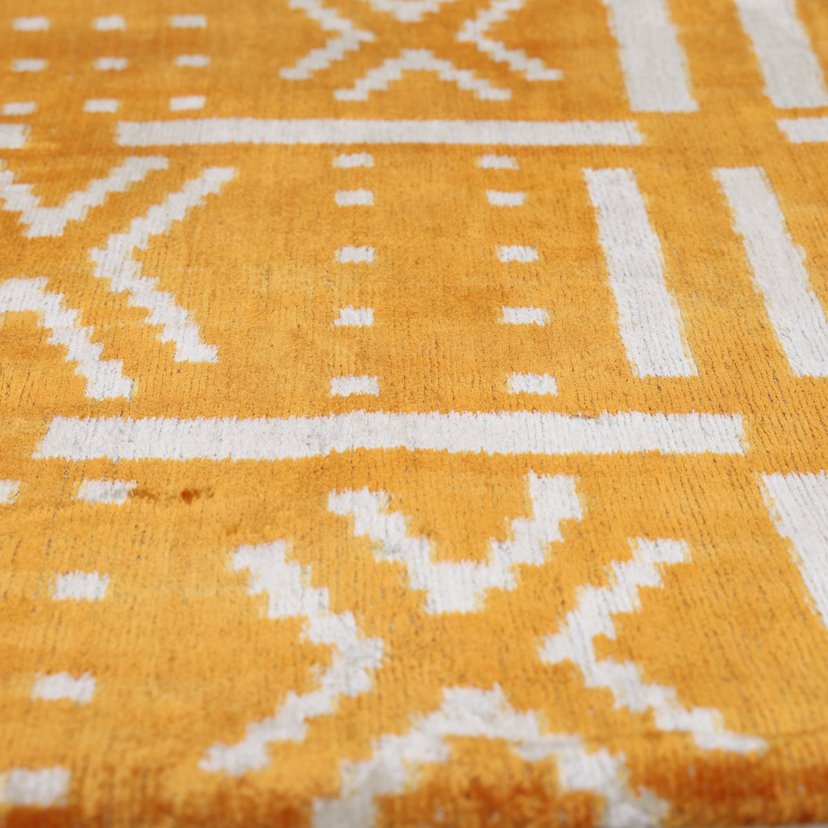 Raking angle showing marigold yellow and ivory white velvet texture and sheen