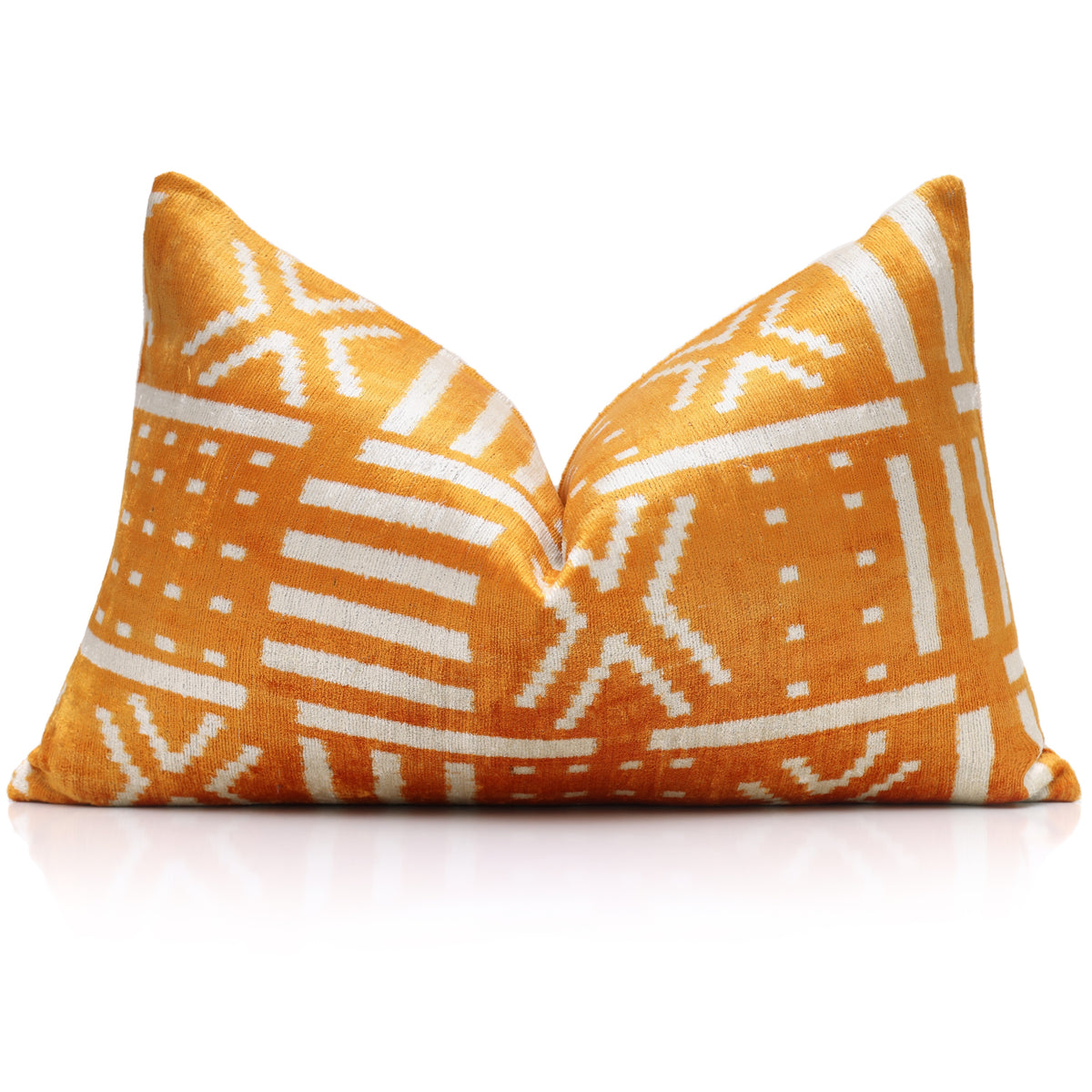 Styled marigold yellow and ivory white geometric lumbar pillow with center karate chop on reflective surface