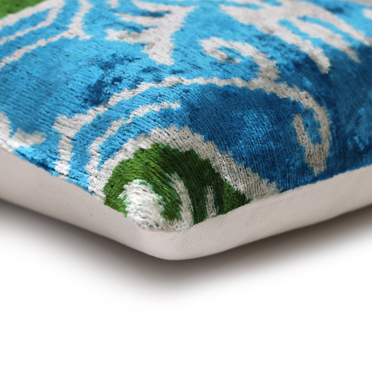 Lumbar pillow corner showing the seam and linen backing beside the teal velvet front