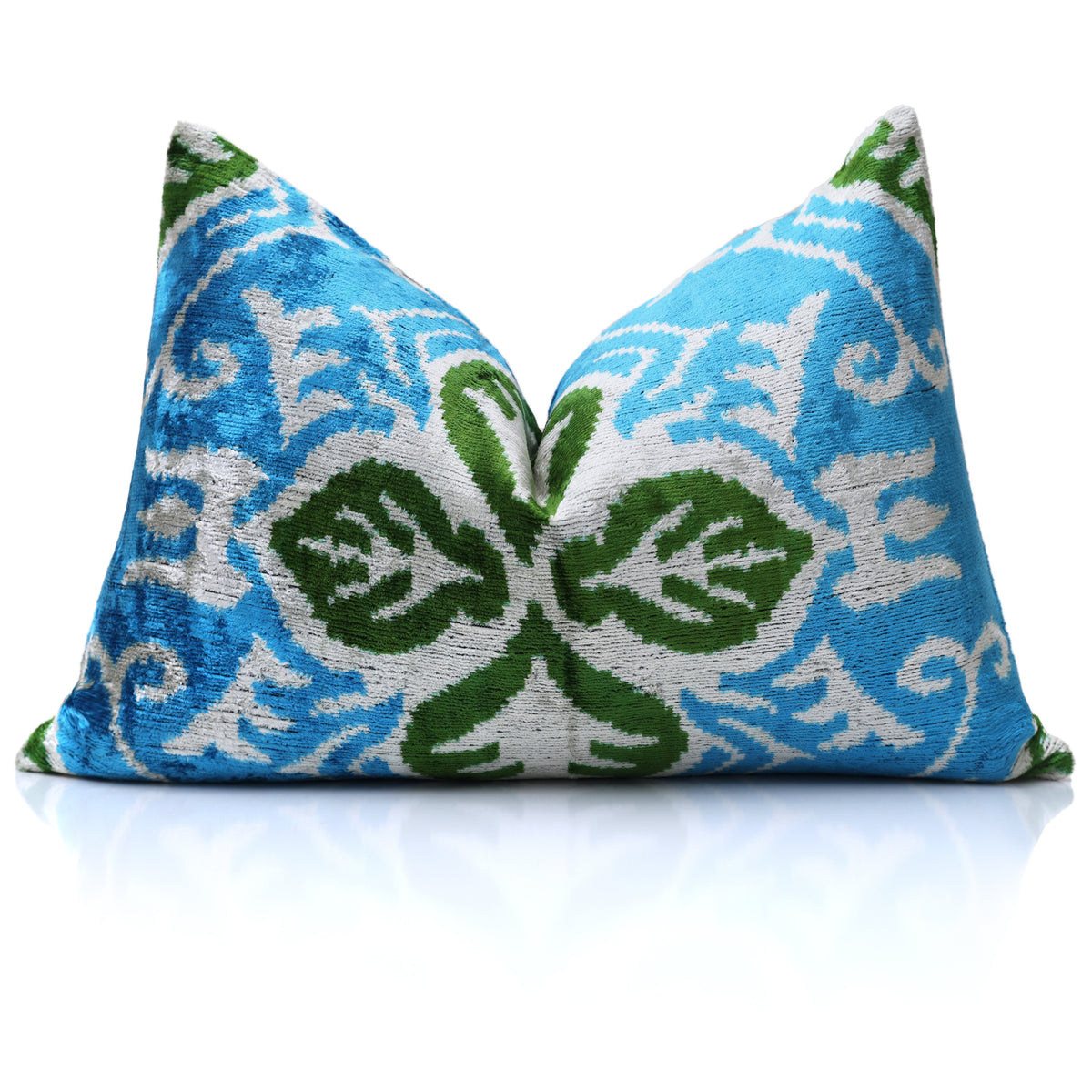 Cerulean teal, soft white and bright olive green ikat lumbar pillow styled with a center karate chop