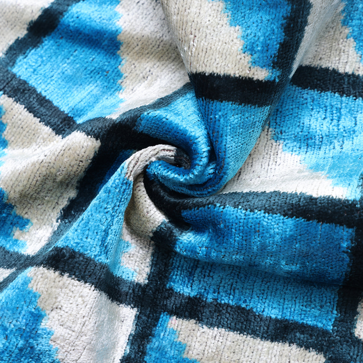 Close detail of cerulean blue silk velvet folded into swirling plush fabric
