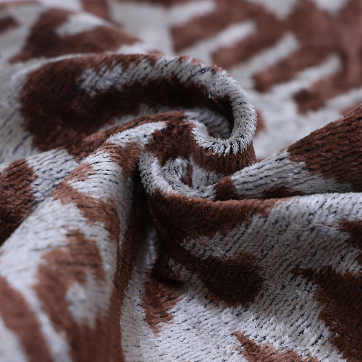 Macro view of warm brown and silvery white velvet folds