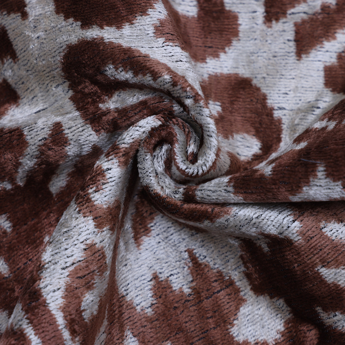 Detail of warm brown and silvery white gathered velvet showing plush texture