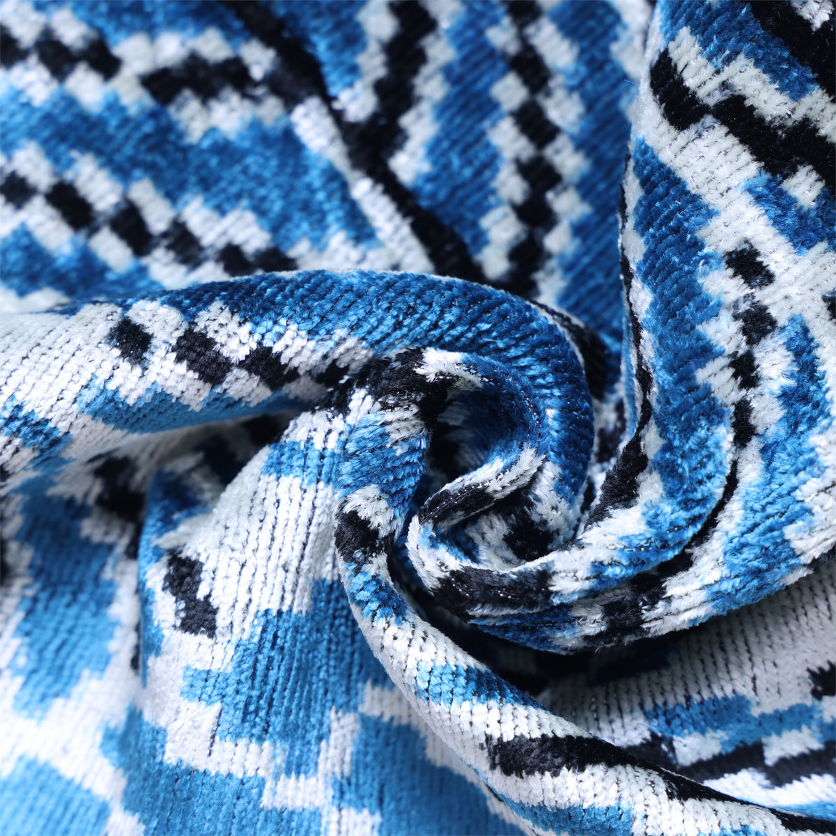 Spiral-fold detail showing cerulean velvet texture and patterned surface
