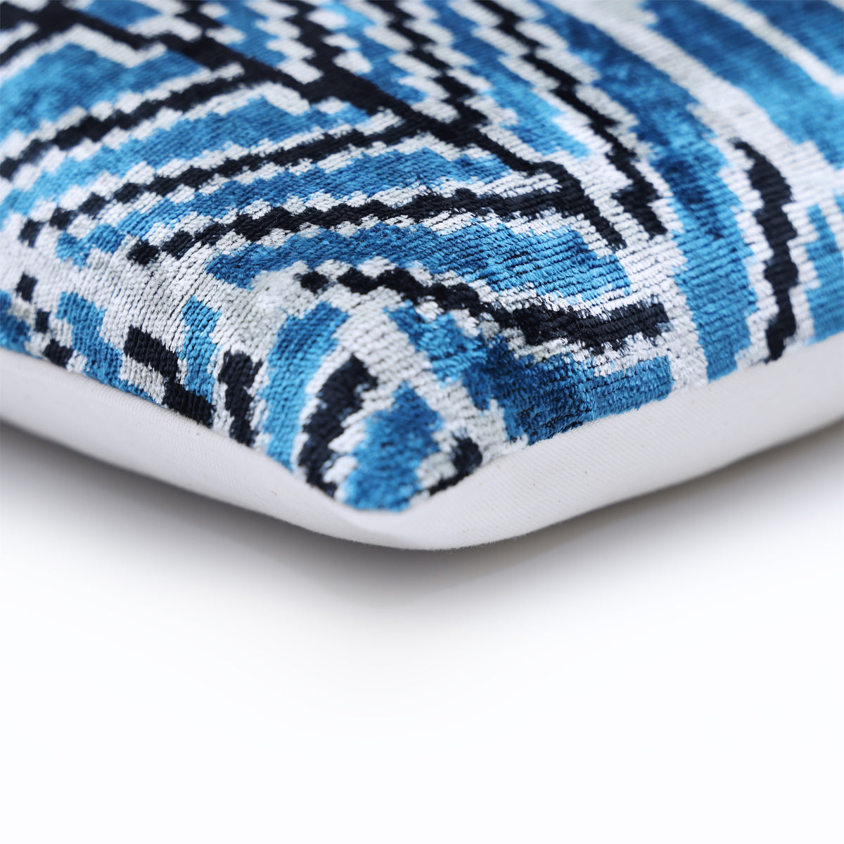 Corner view of blue ikat velvet face with linen backing edge