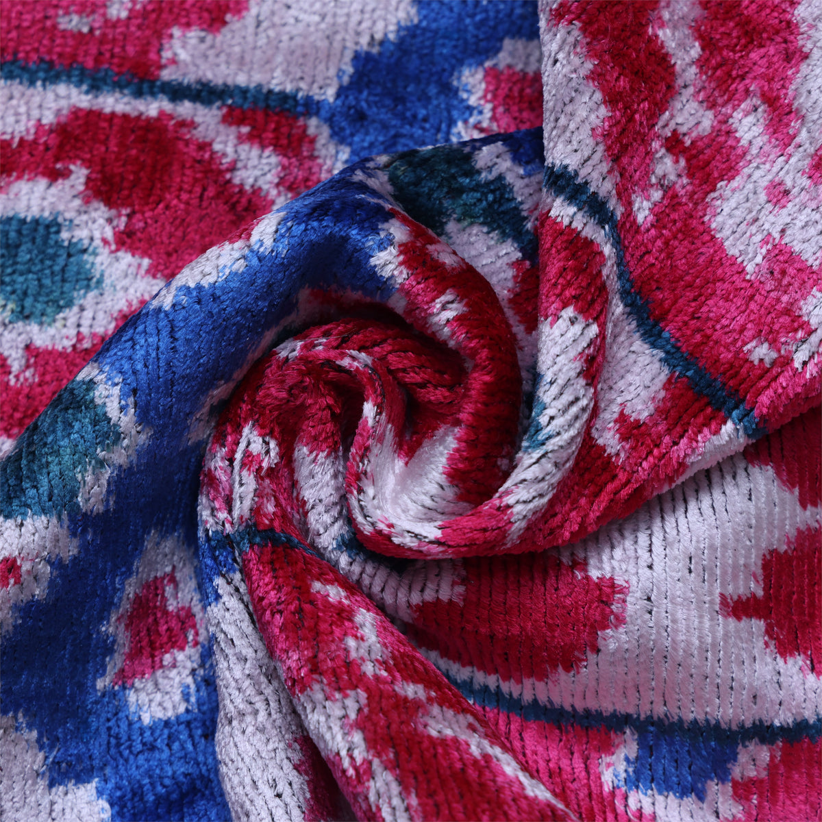 Close-up of magenta pink and white ikat motif on plush silk velvet
