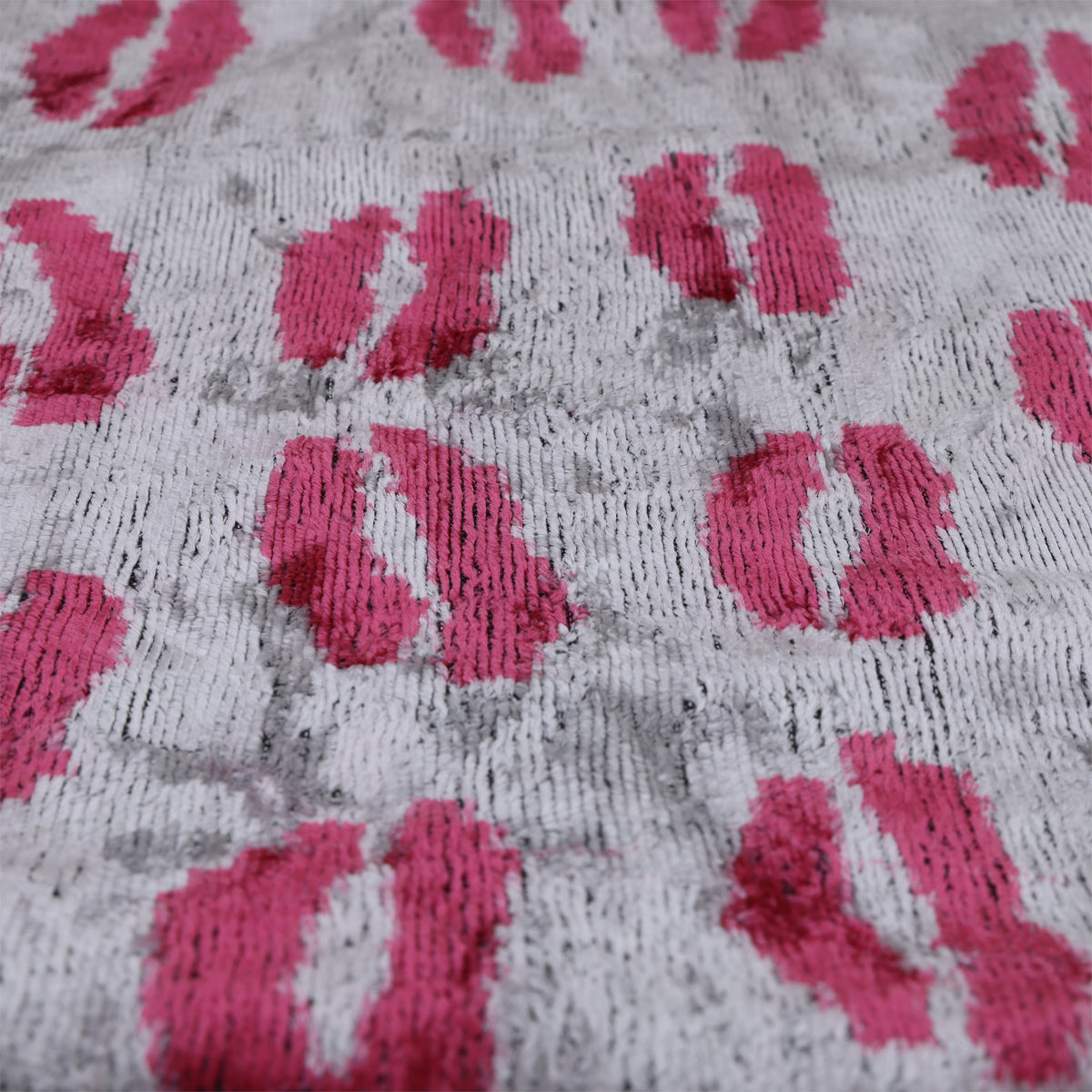 Angled silver gray velvet surface with fuchsia pink lips motif and visible pile