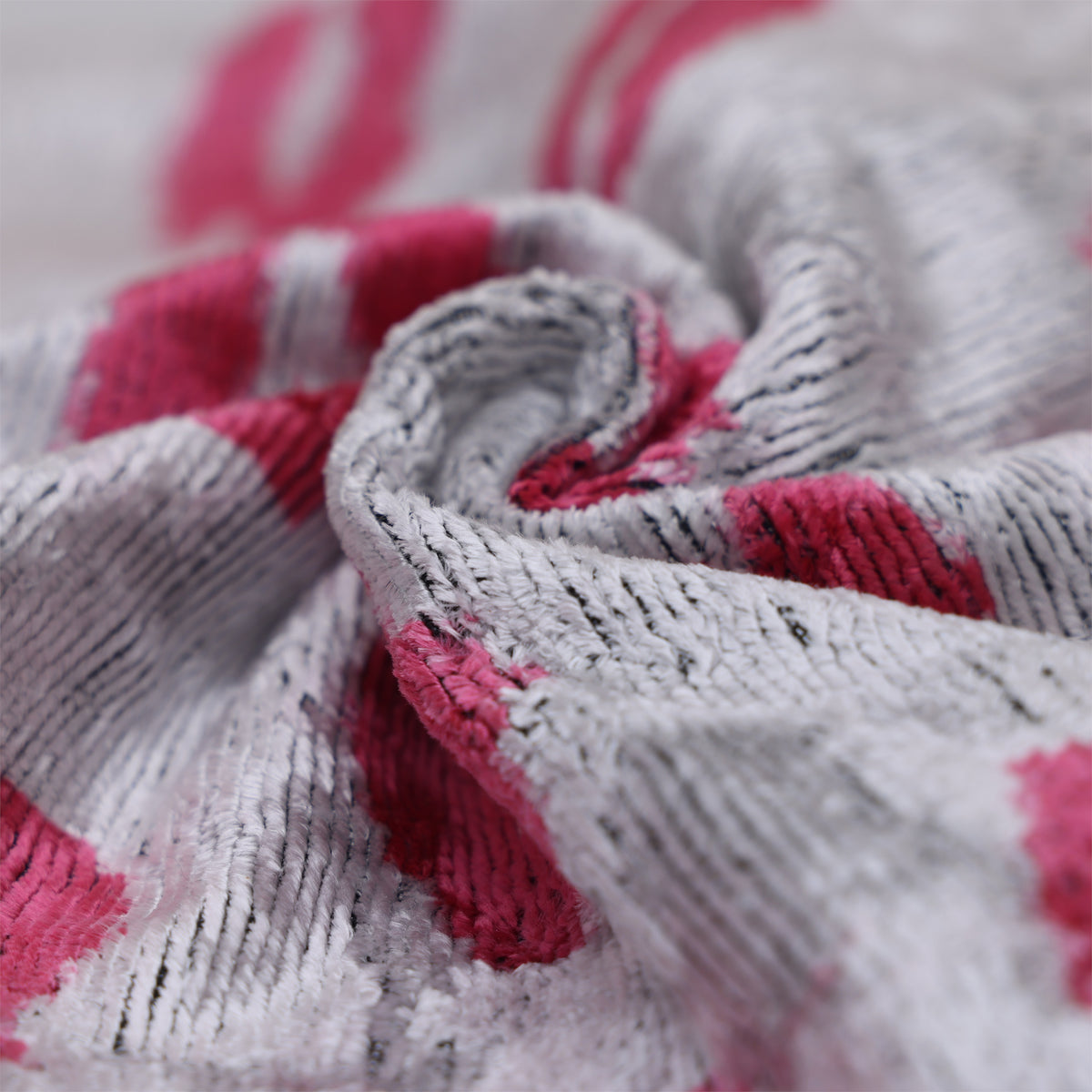 Close-up of swirled silver gray and fuchsia pink velvet fabric