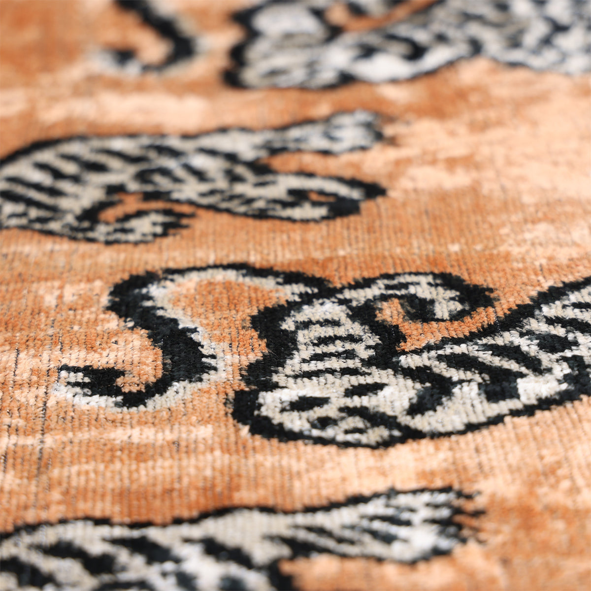 Angled view of camel velvet surface with black and soft white tiger motifs