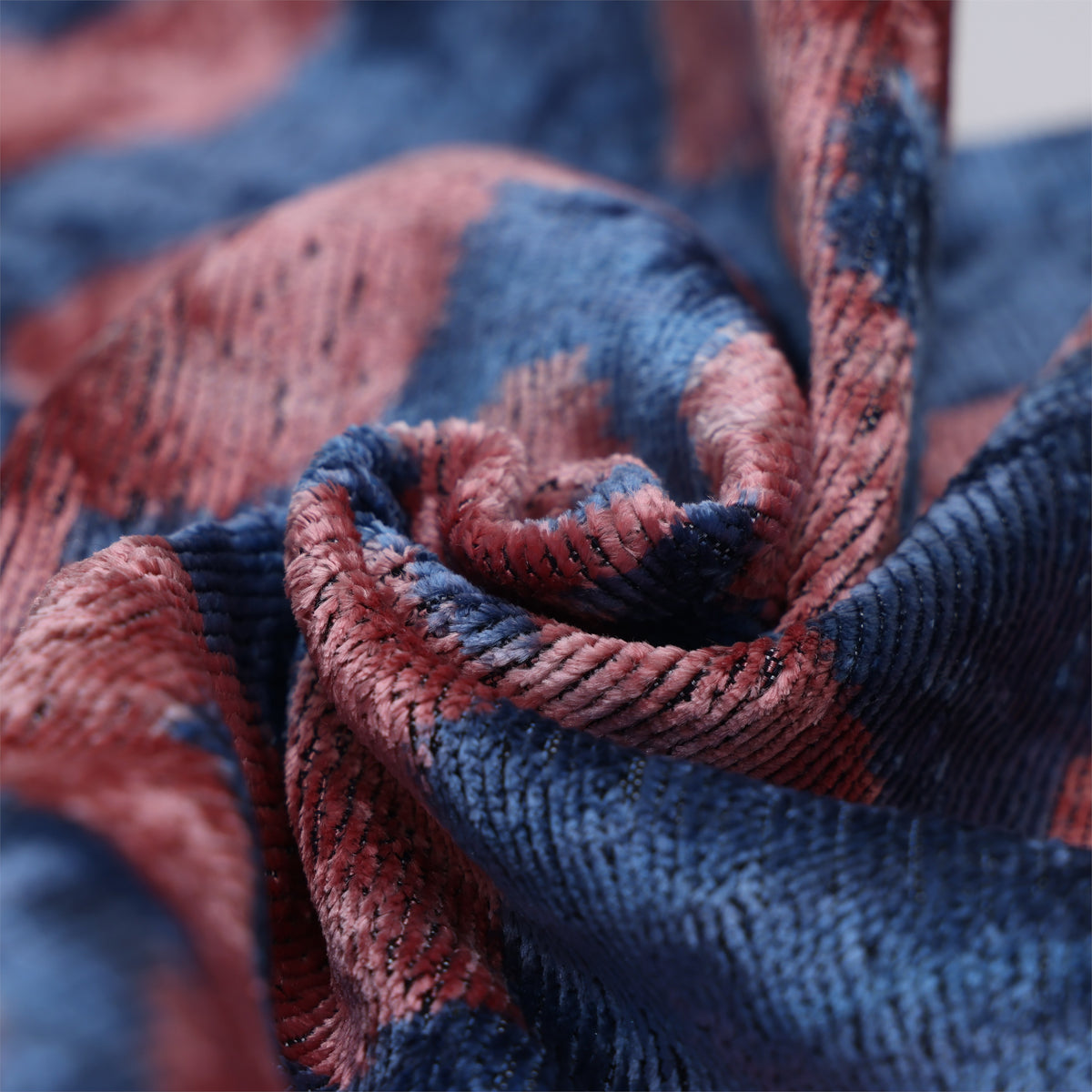 Macro detail of gathered slate blue and dusty rose pink velvet folds