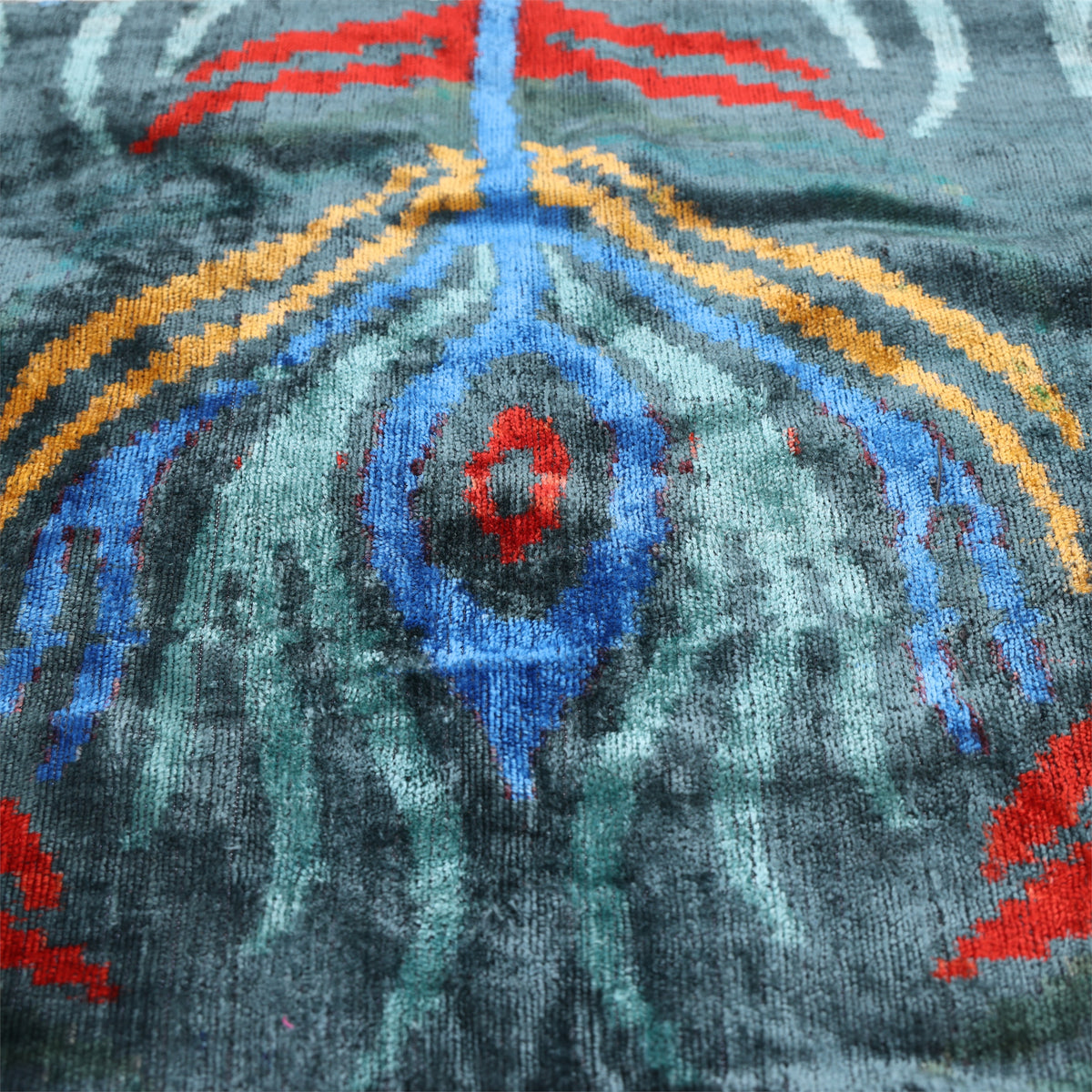 Central ikat peacock eye medallion in dark teal, aqua blue, cobalt blue and crimson red