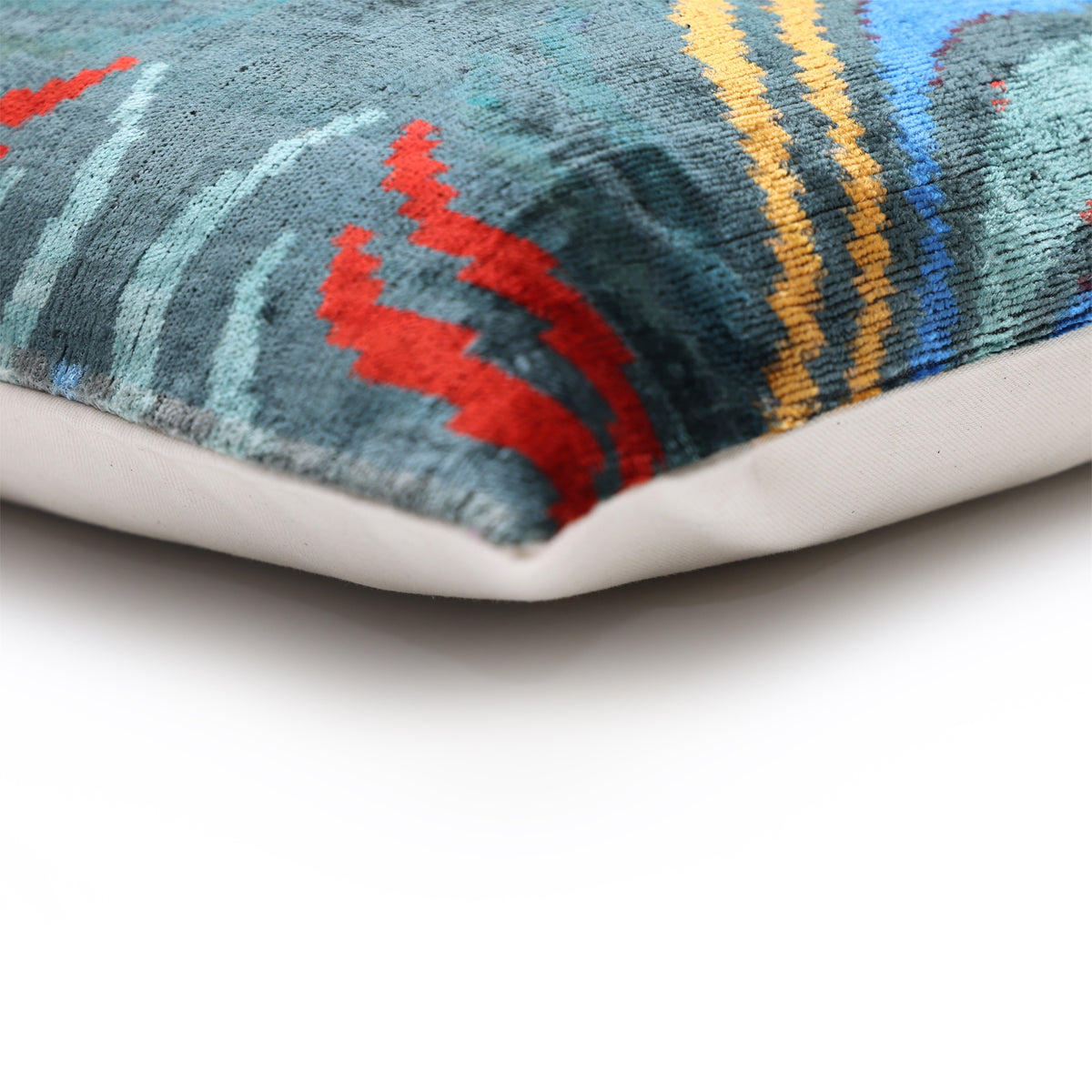 Corner seam and edging on dark teal ikat silk velvet lumbar pillow