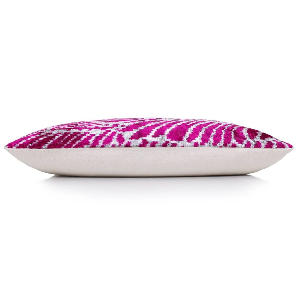Side profile of magenta pink and crisp white lumbar pillow showing thickness and plain linen backing