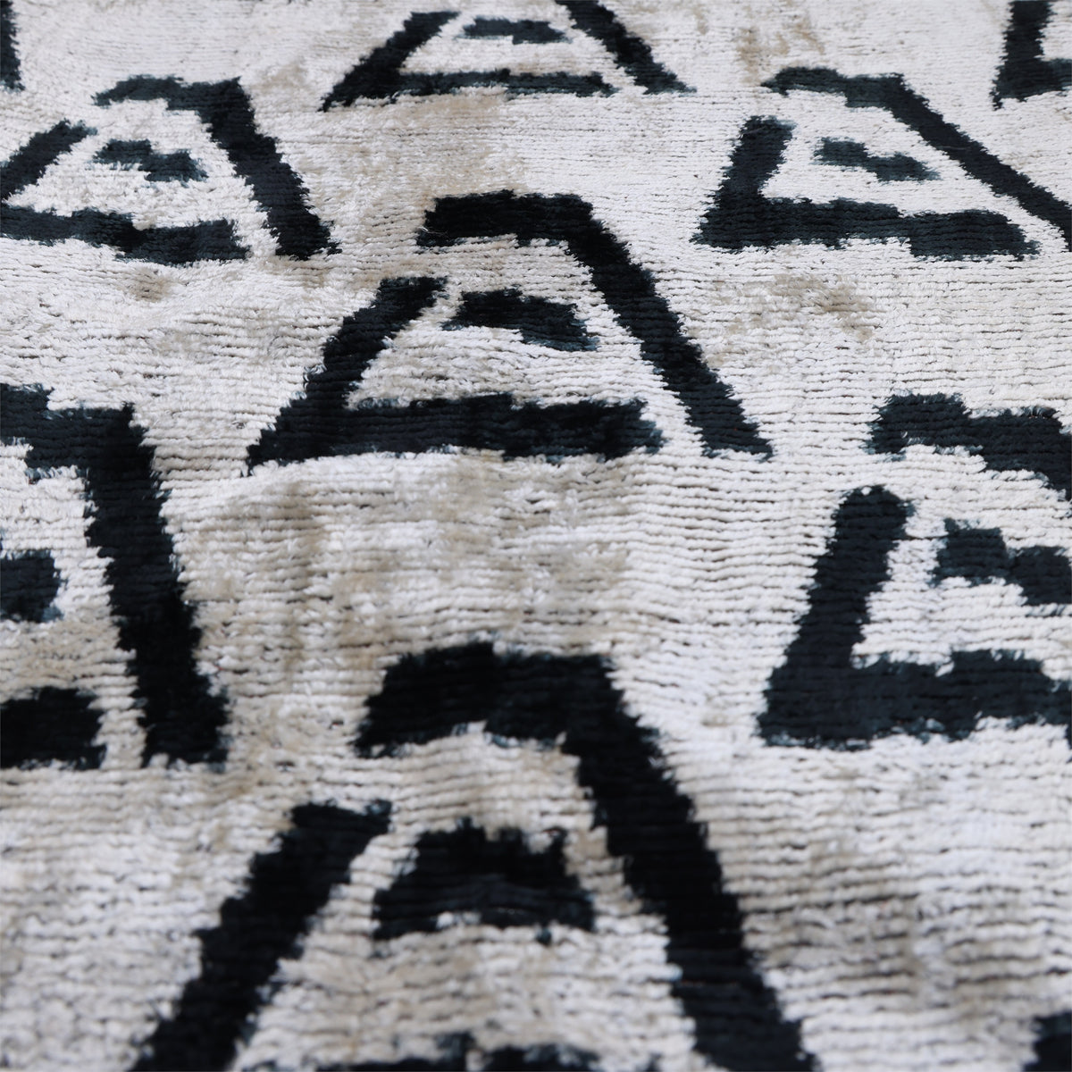 Low-angle view of black, ivory and sand beige geometric velvet pattern