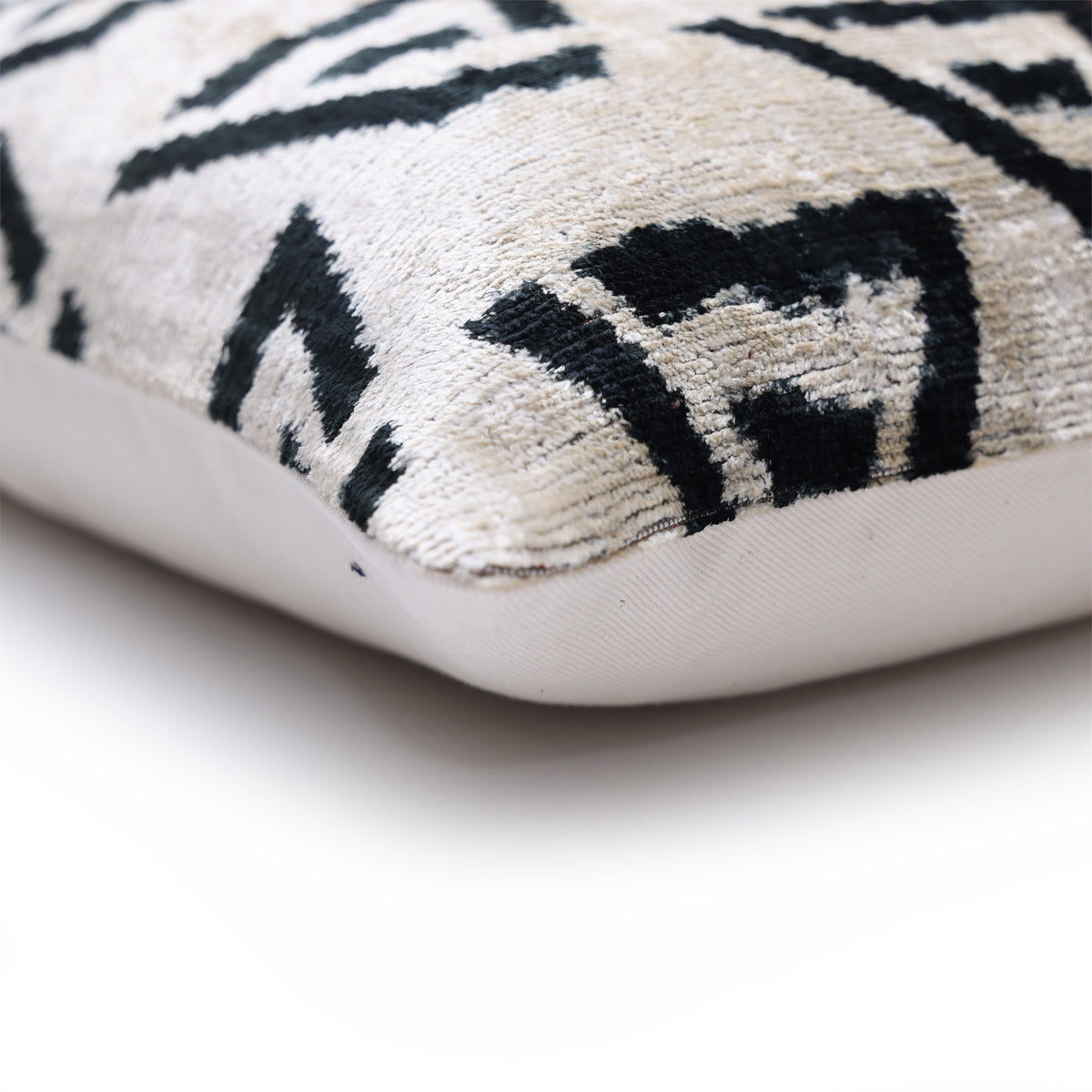 Corner detail of ivory velvet pillow with finished seam and pile
