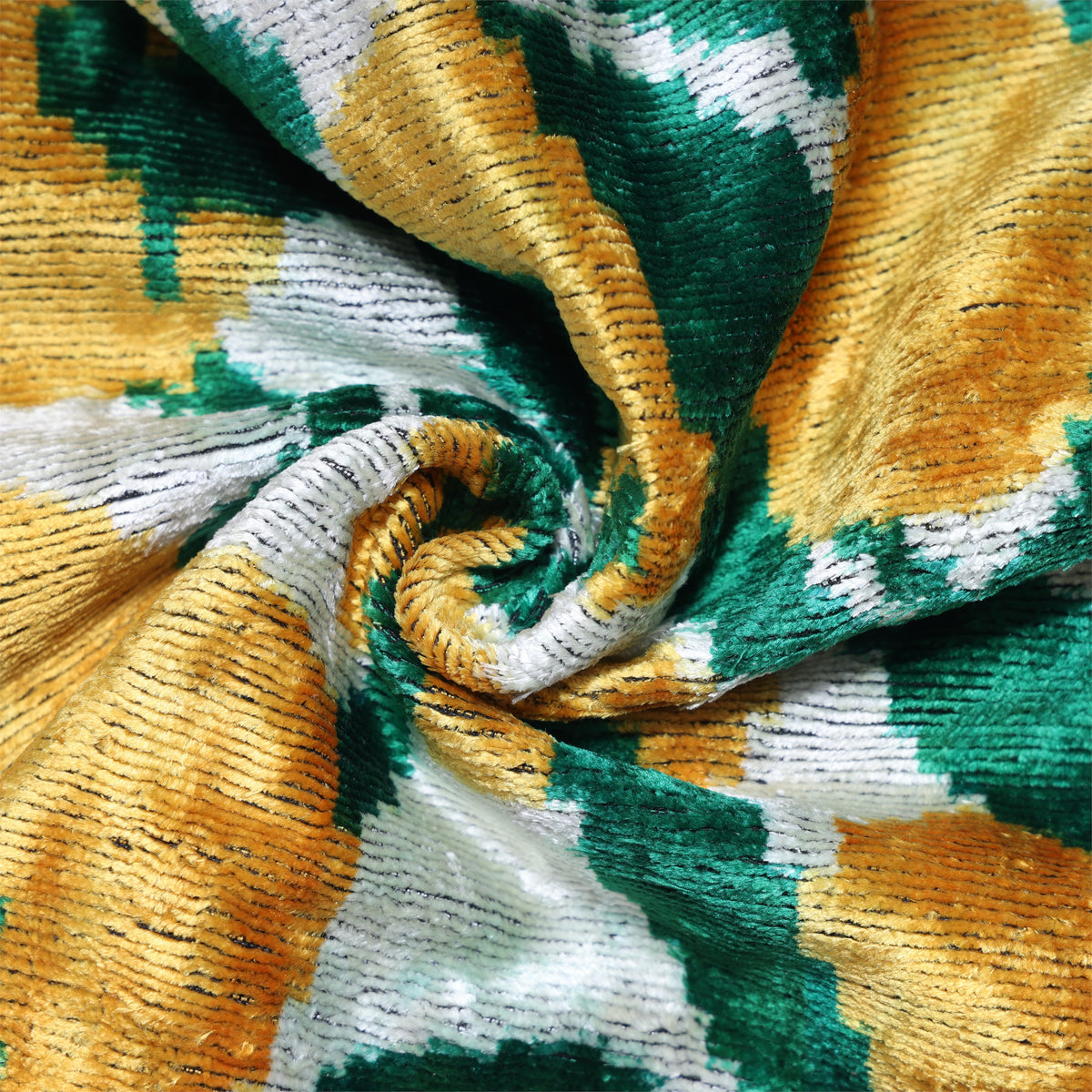 Close-up spiral fold showing ochre gold and emerald green cut-velvet ribs