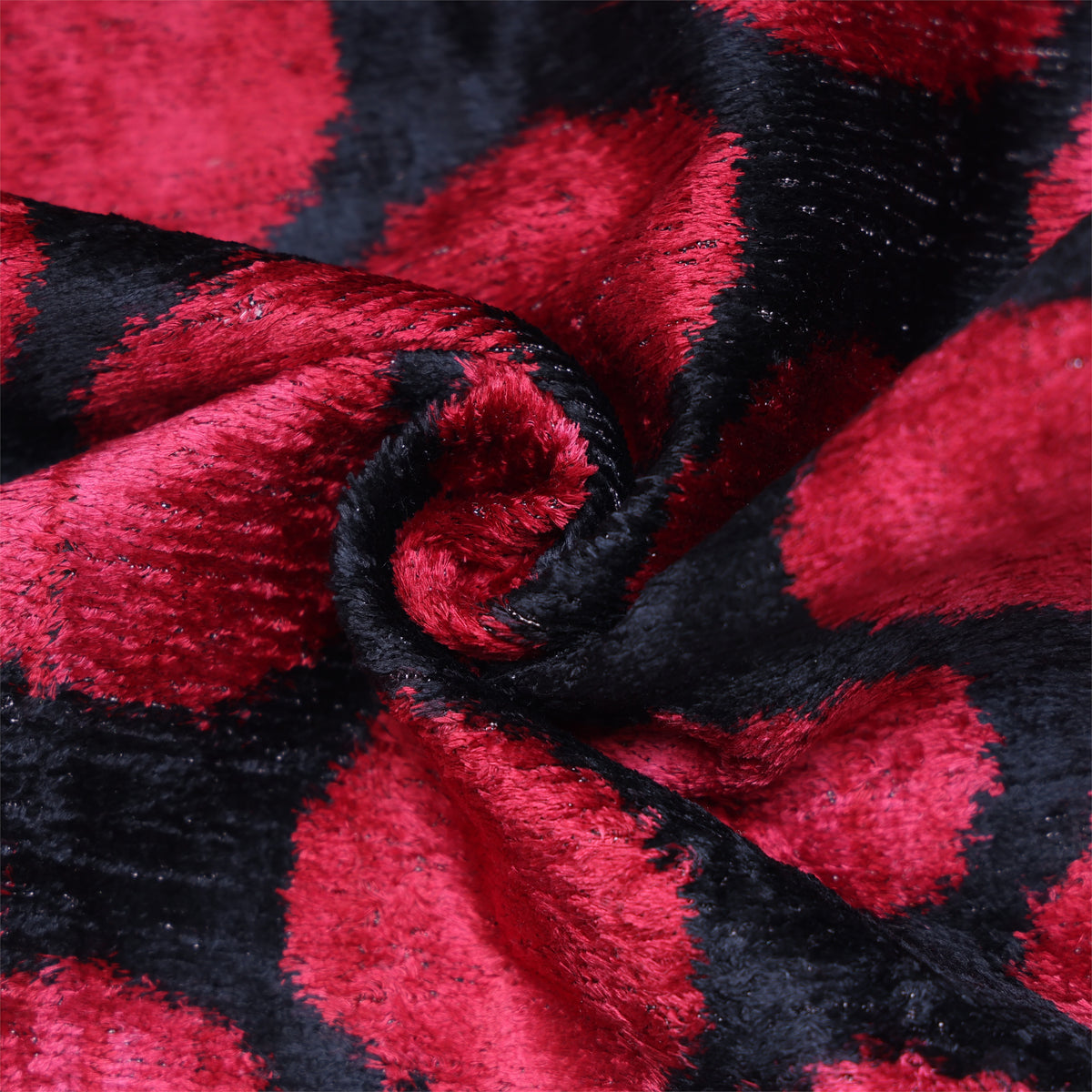 Swirled close-up of crimson red and black polka dot silk velvet texture