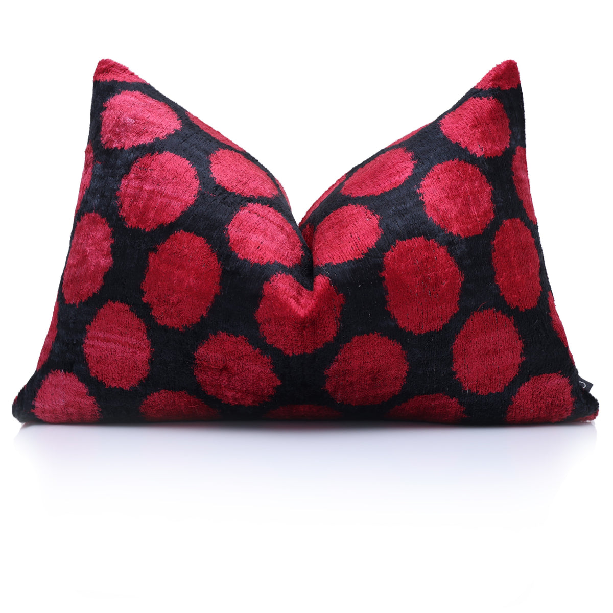 Crimson red and black polka dot lumbar pillow styled with a center chop