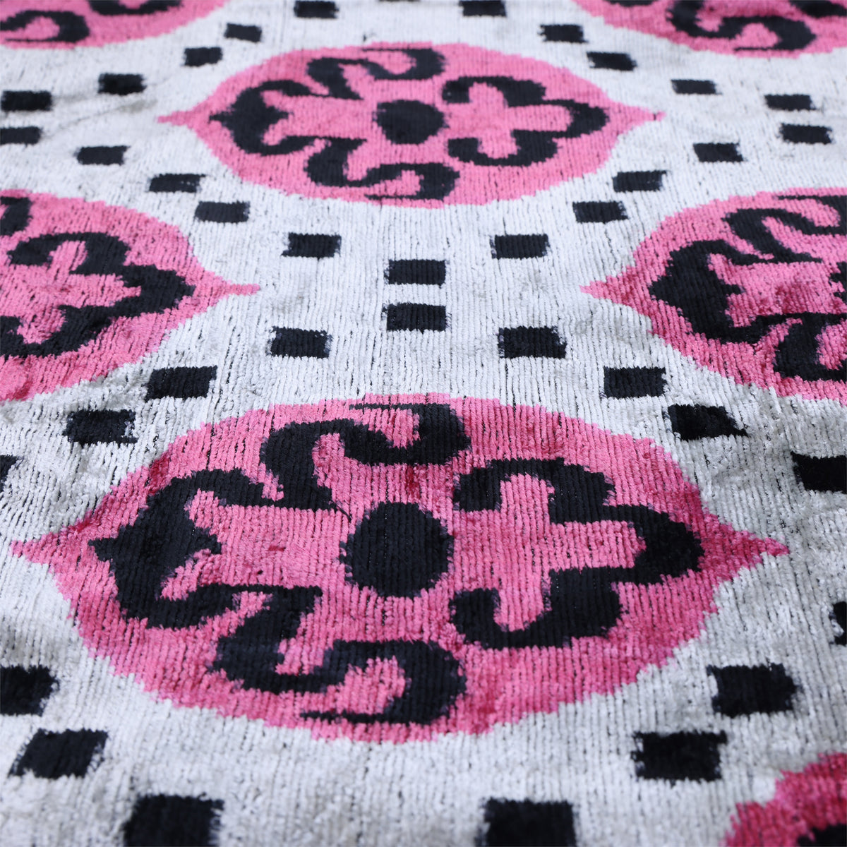 Low-angle close-up showing the soft velvet pile and geometric medallion motifs