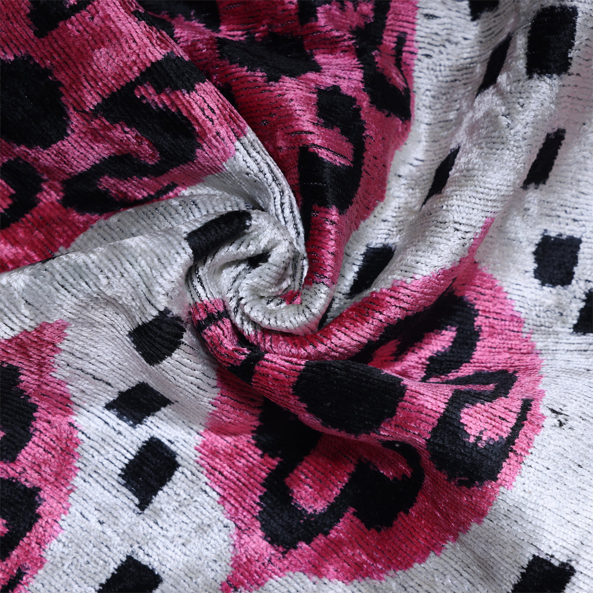 Close-up of gathered silk velvet showing magenta pink and black medallion pattern