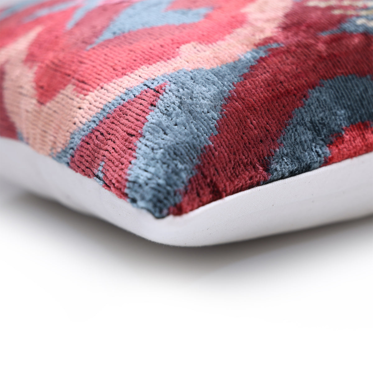 Corner detail of crimson red velvet seam and textured cut-velvet pile