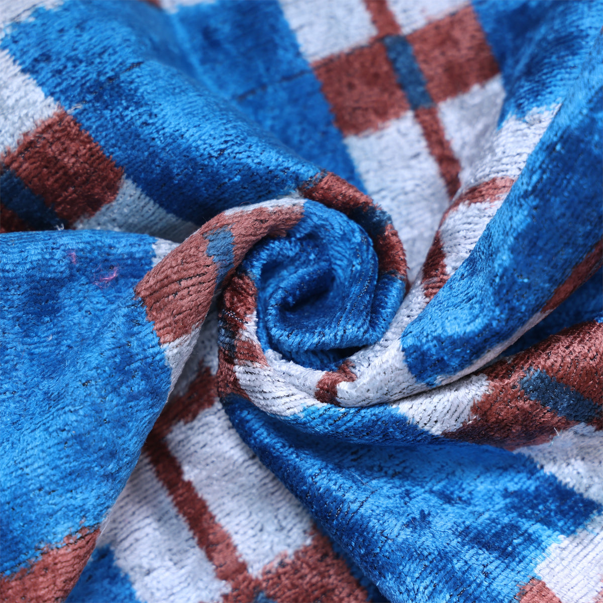 Overhead detail showing the swirled cut velvet texture in a bright cobalt blue plaid pattern