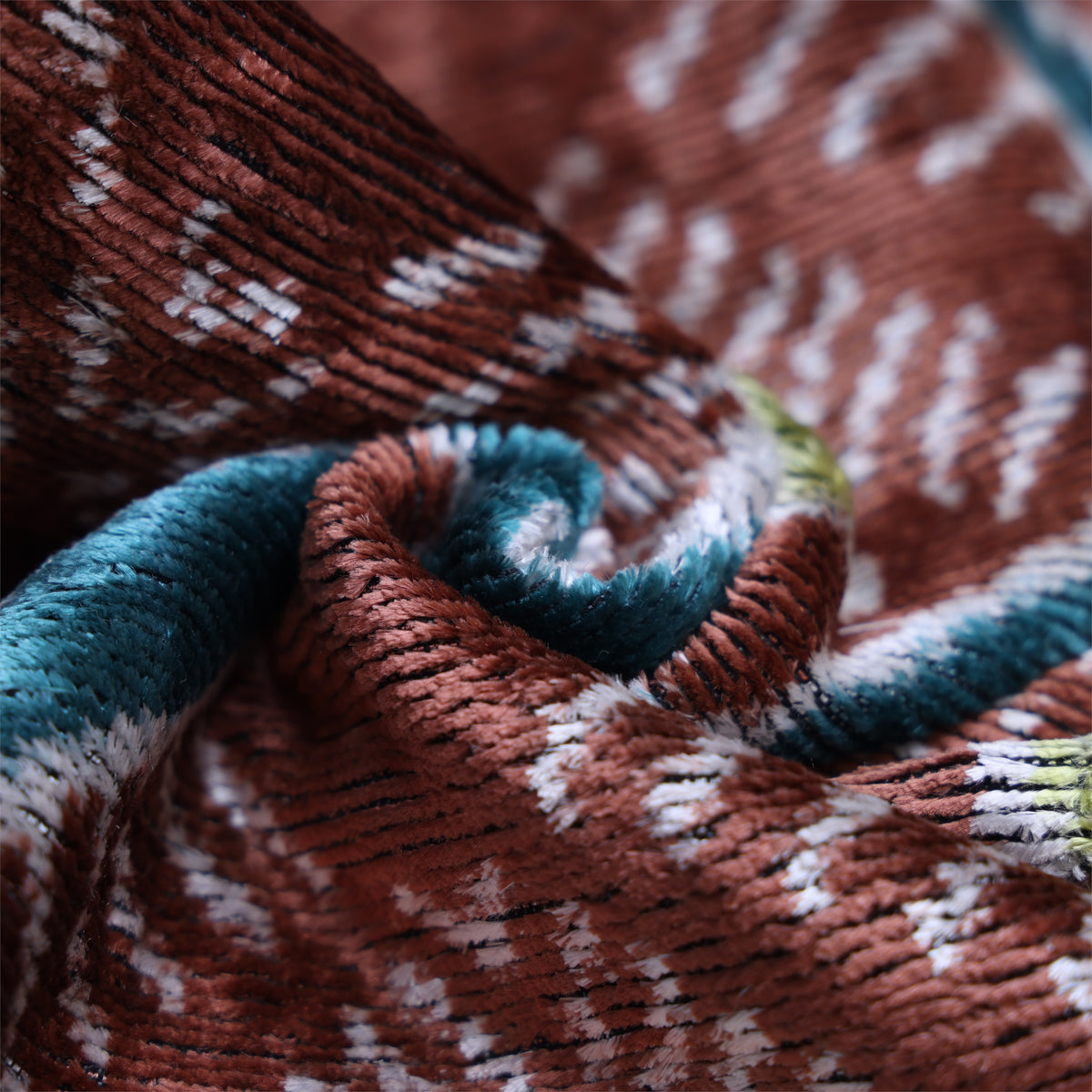Macro swirl showing velvet pile and transition between terracotta rust and deep teal blue
