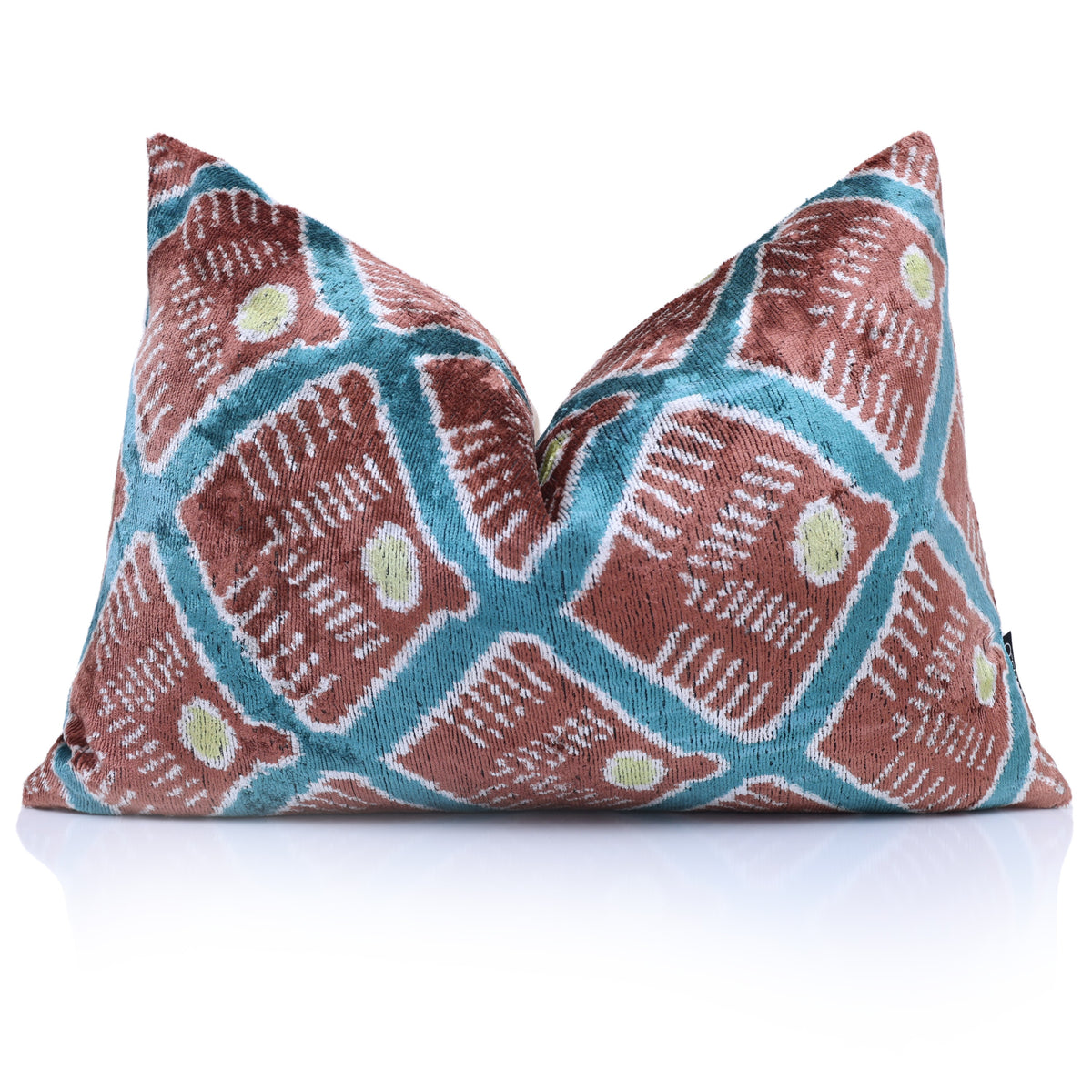 Terracotta rust and deep teal blue ikat lumbar pillow styled with a karate chop crease