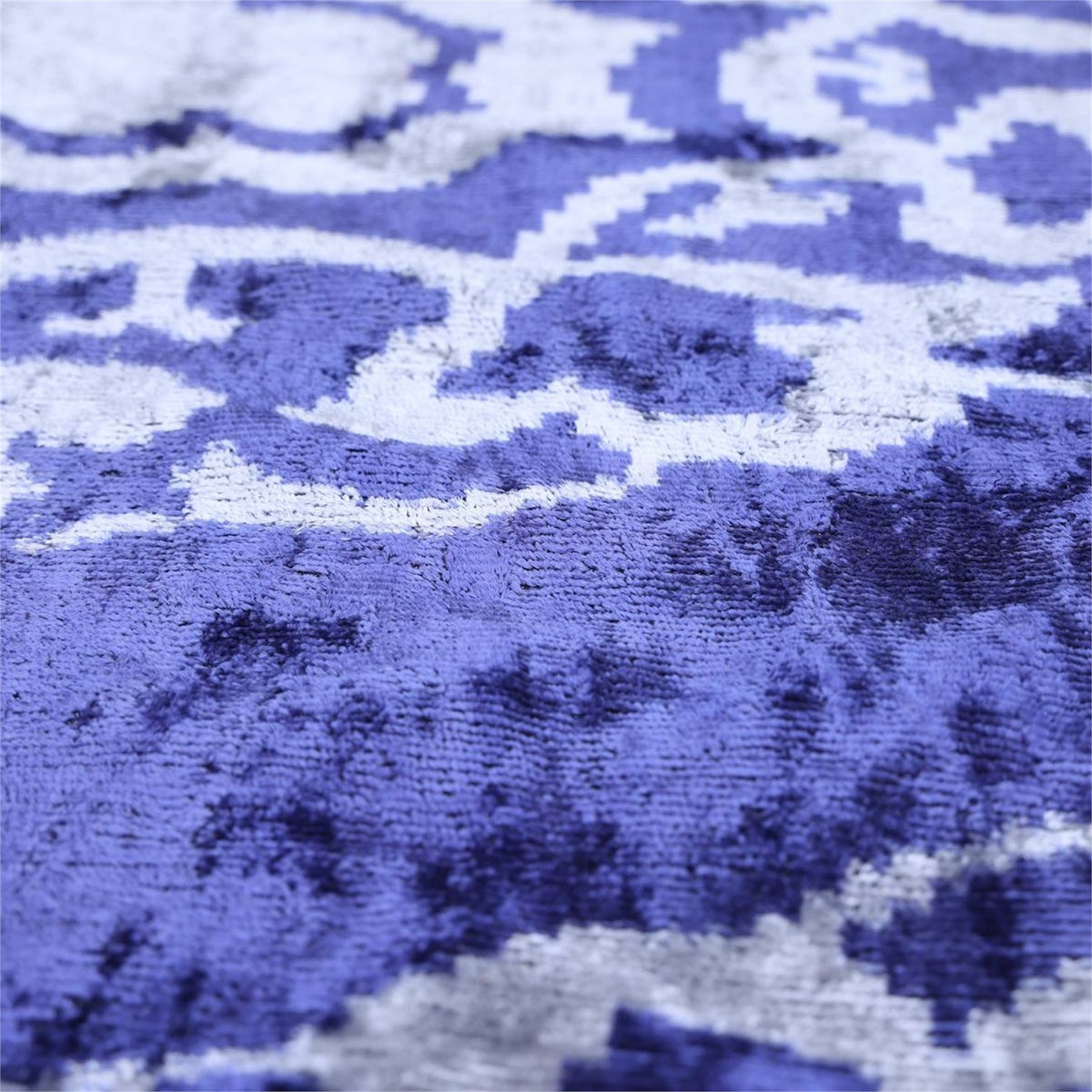 Plush cobalt blue velvet surface with silvery light gray ikat detail