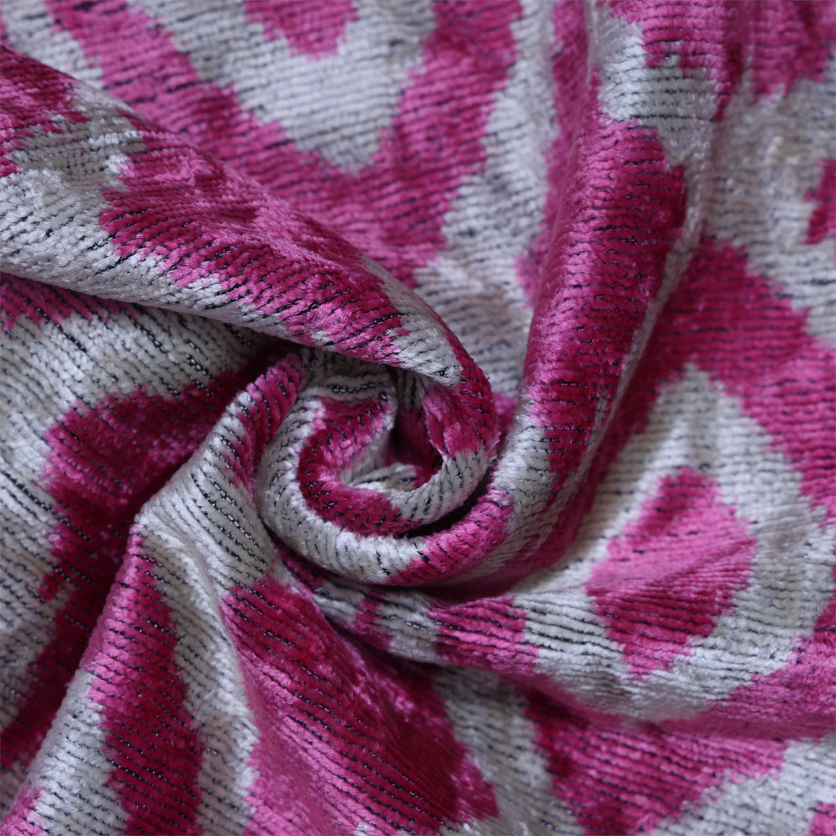 Close-up of fuchsia pink and silvery white ribbed velvet showing woven pile texture