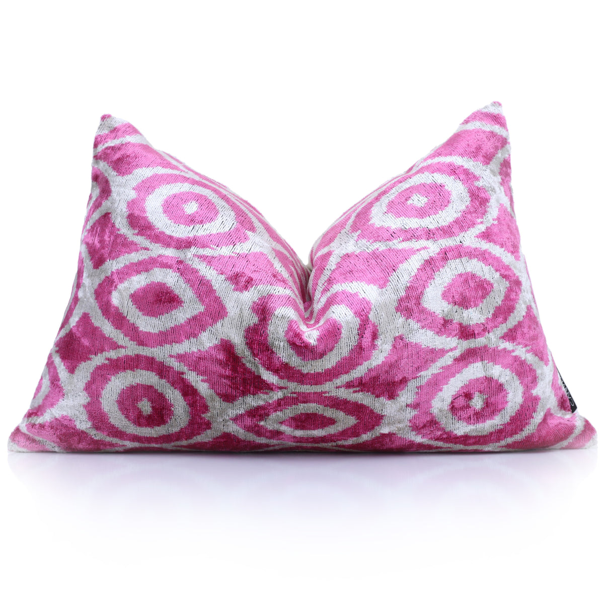 Fuchsia pink and silvery white geometric ikat lumbar pillow styled with a karate chop crease